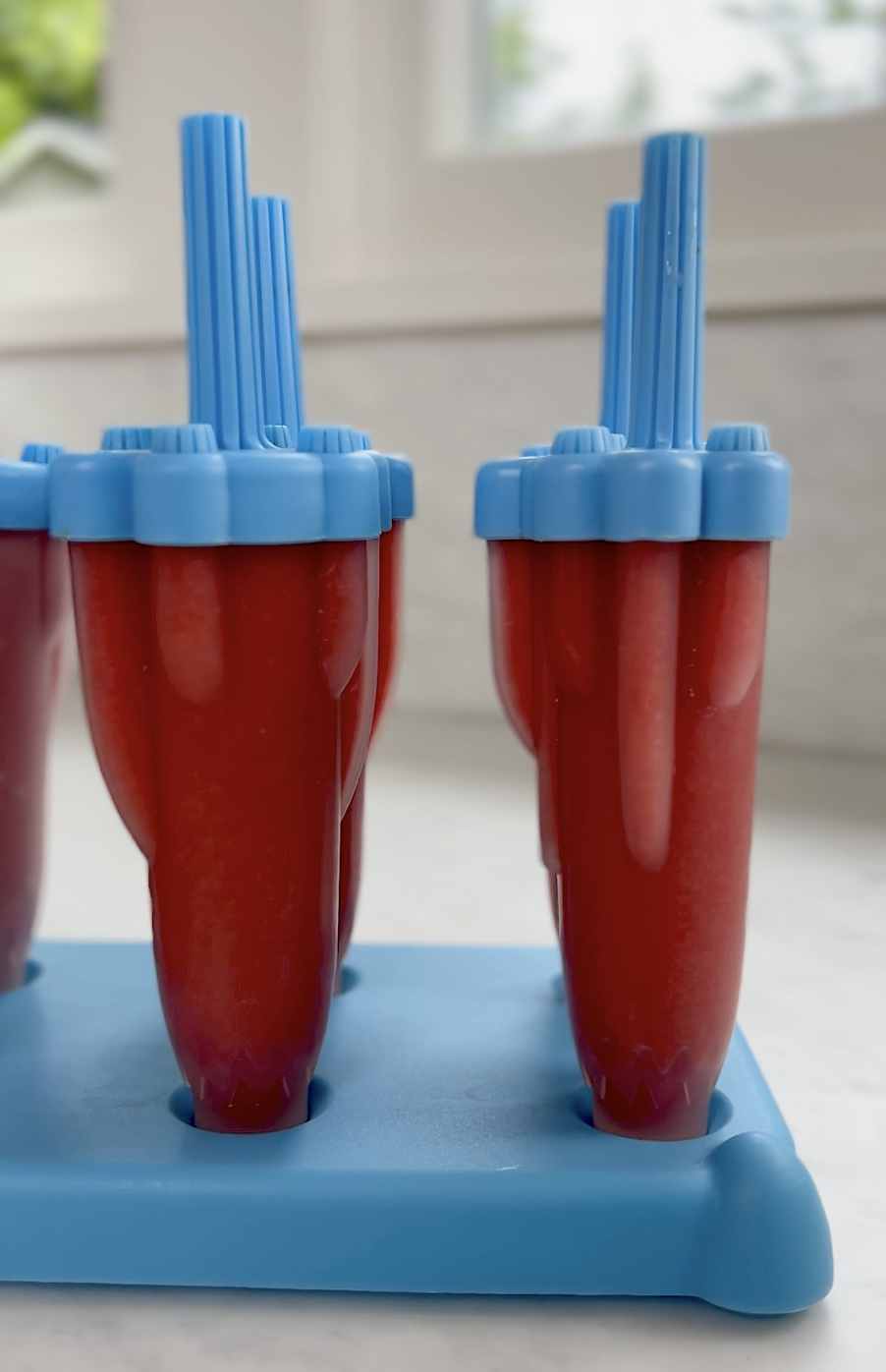 Strawberry Popsicles in molds.