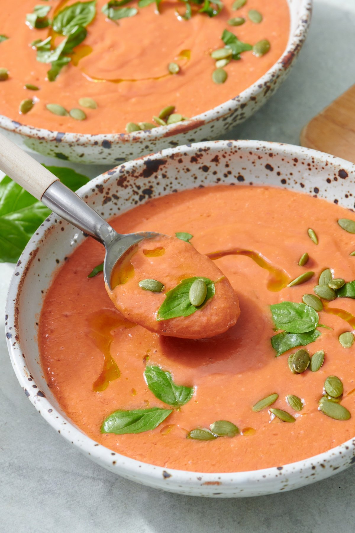 Quick and easy gazpacho being spooned out of a bowl.