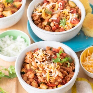 Turkey veggie chili in bowls with toppings.