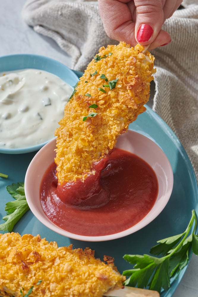 dipping chicken finger in ketchup