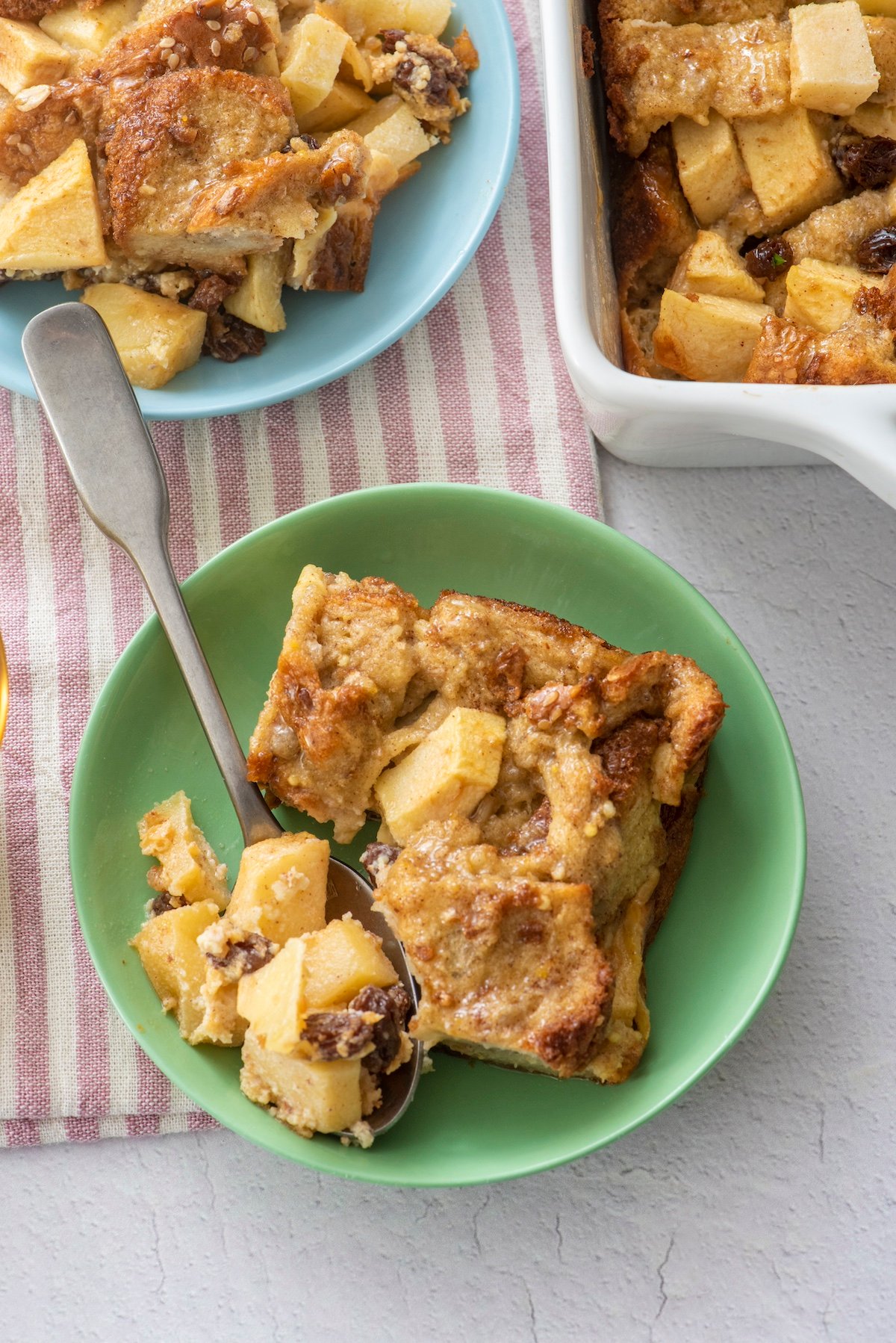 Serving of breakfast bread pudding on green plate.