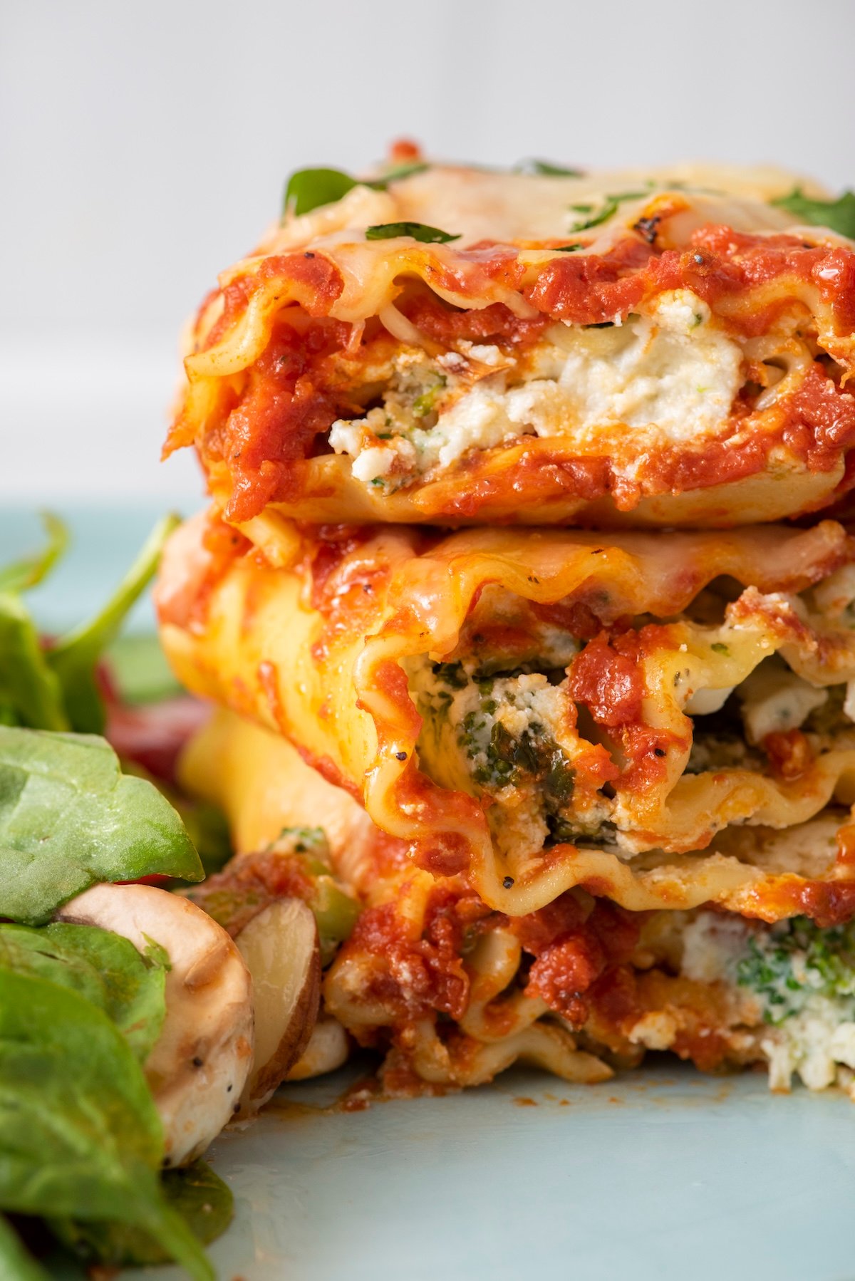 Lasagna rolls stacked on top of each other on a plate.