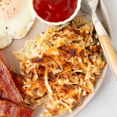 Crispy homemade hash browns with a side of ketchup. Serve with bacon and eggs.