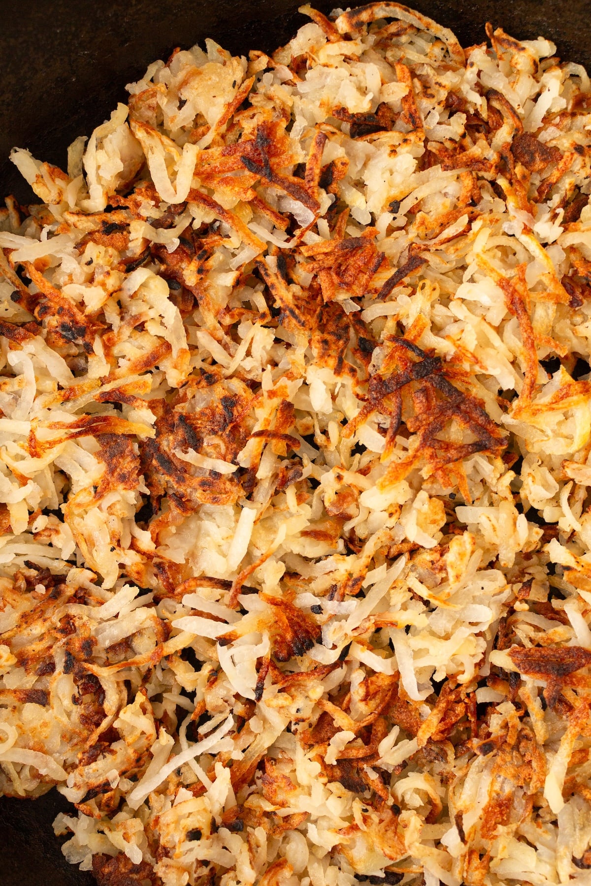 Crispy hash browns in a cast iron skillet.