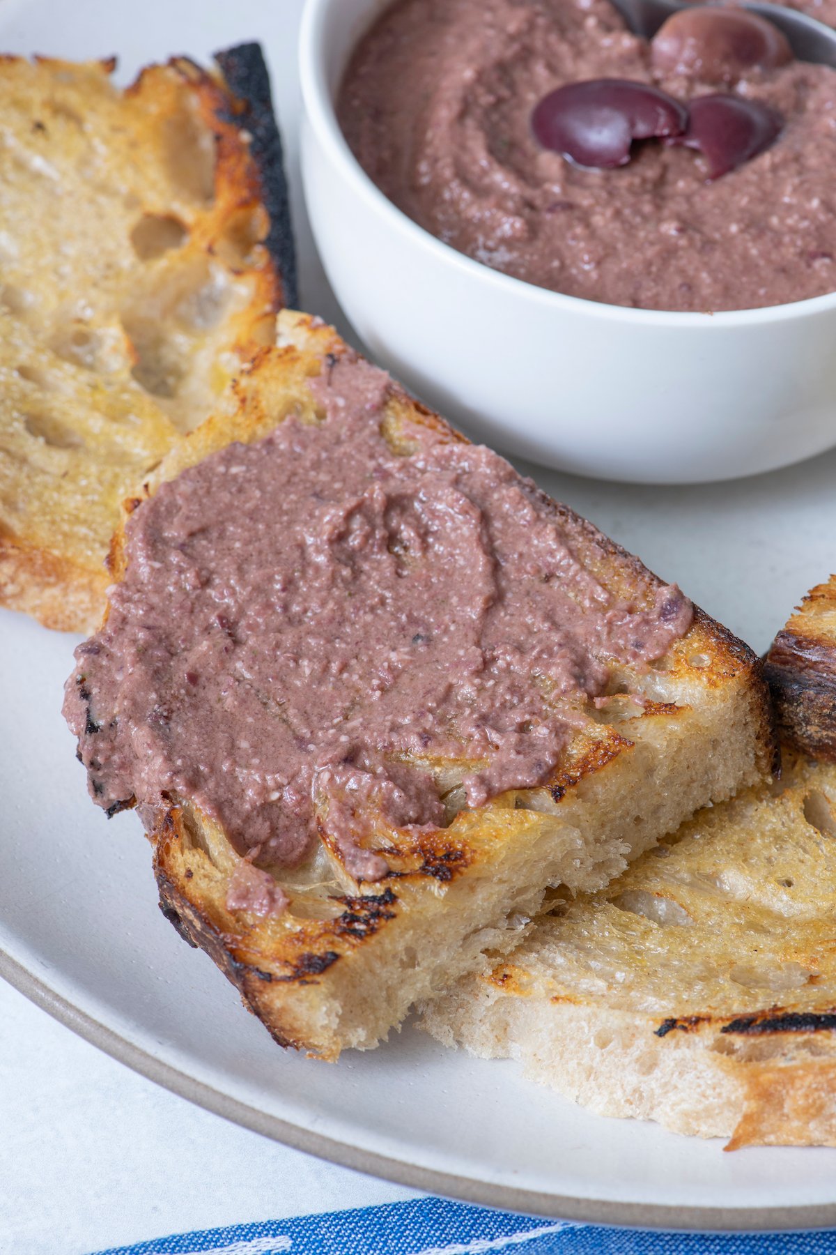 Olive tapenade on piece of crispy bread.