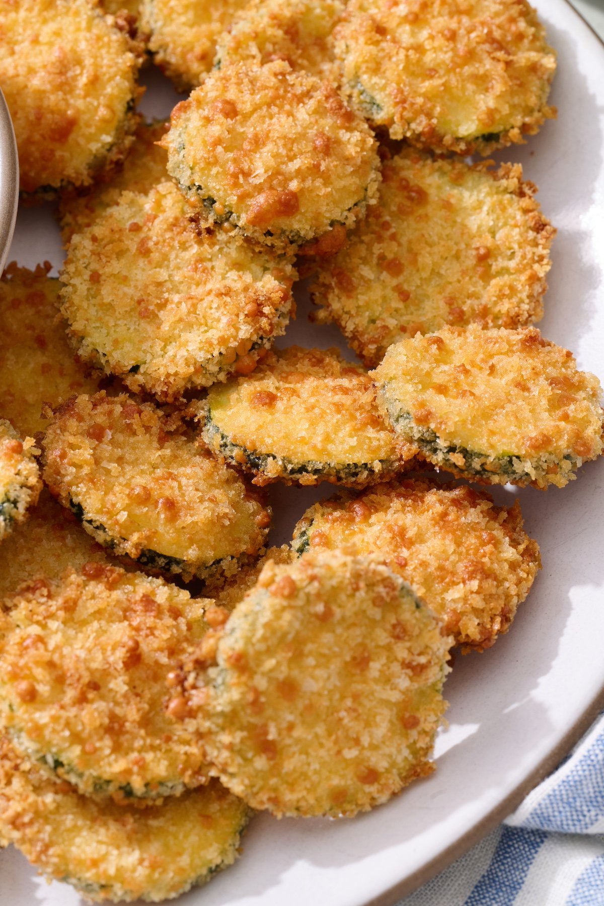 Baked zucchini coins on serving platter.