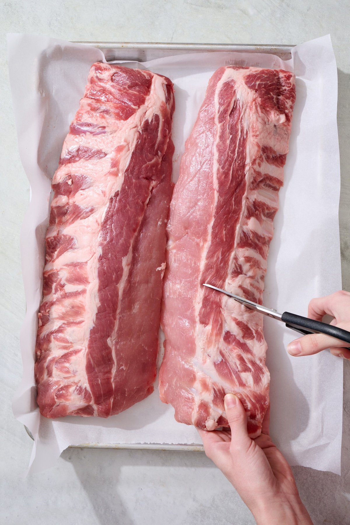 Cutting baby back ribs into smaller portions.