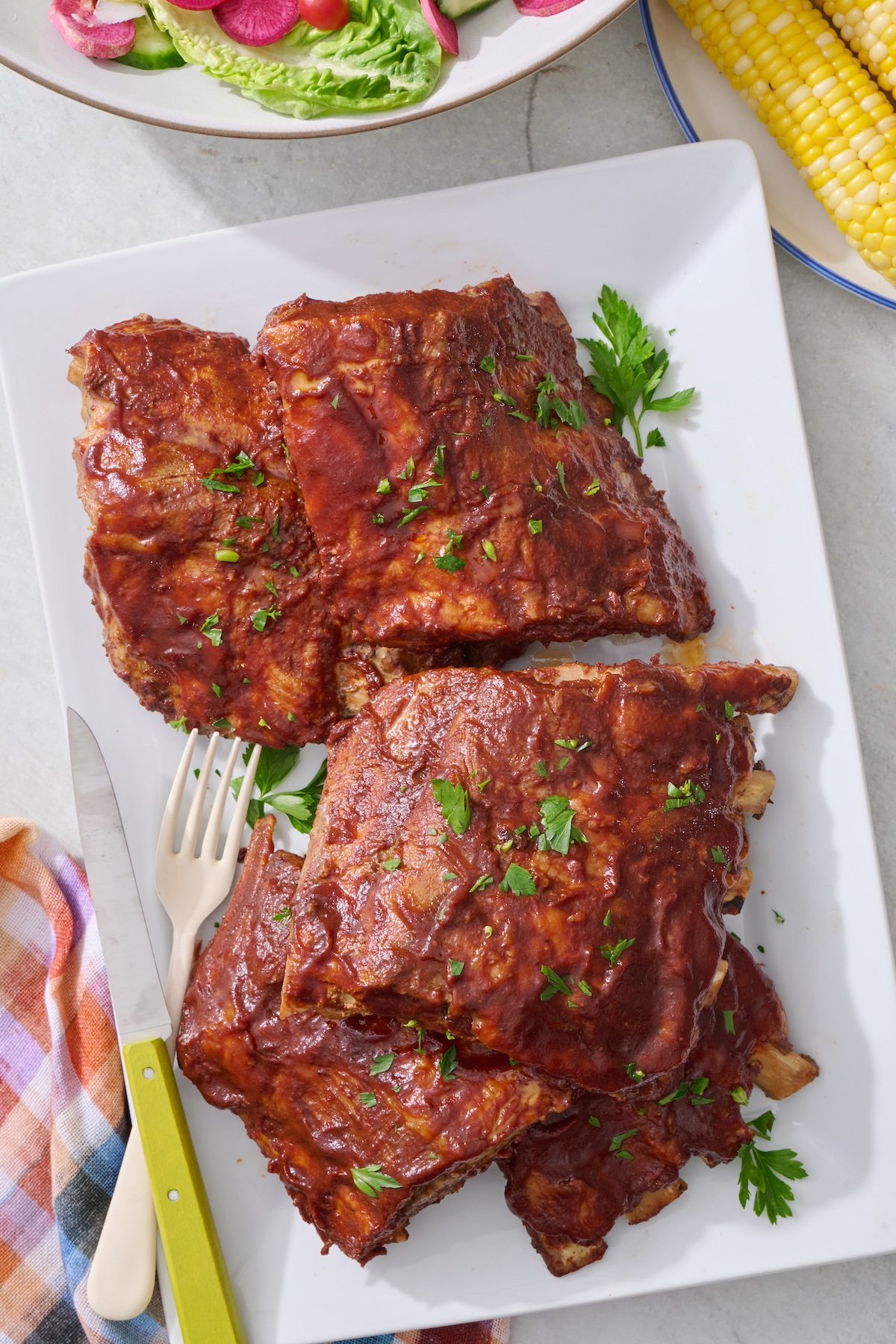 Crock pot ribs with BBQ sauce on a serving platter. 