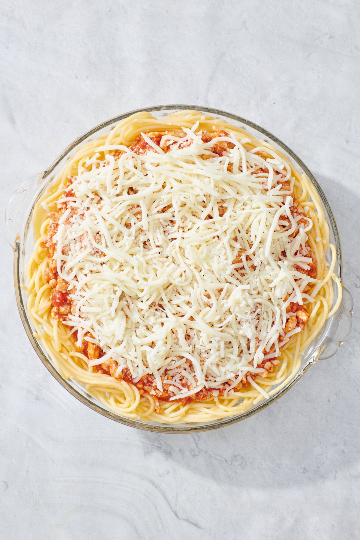 Mozzarella cheese layered on top of spaghetti pie.