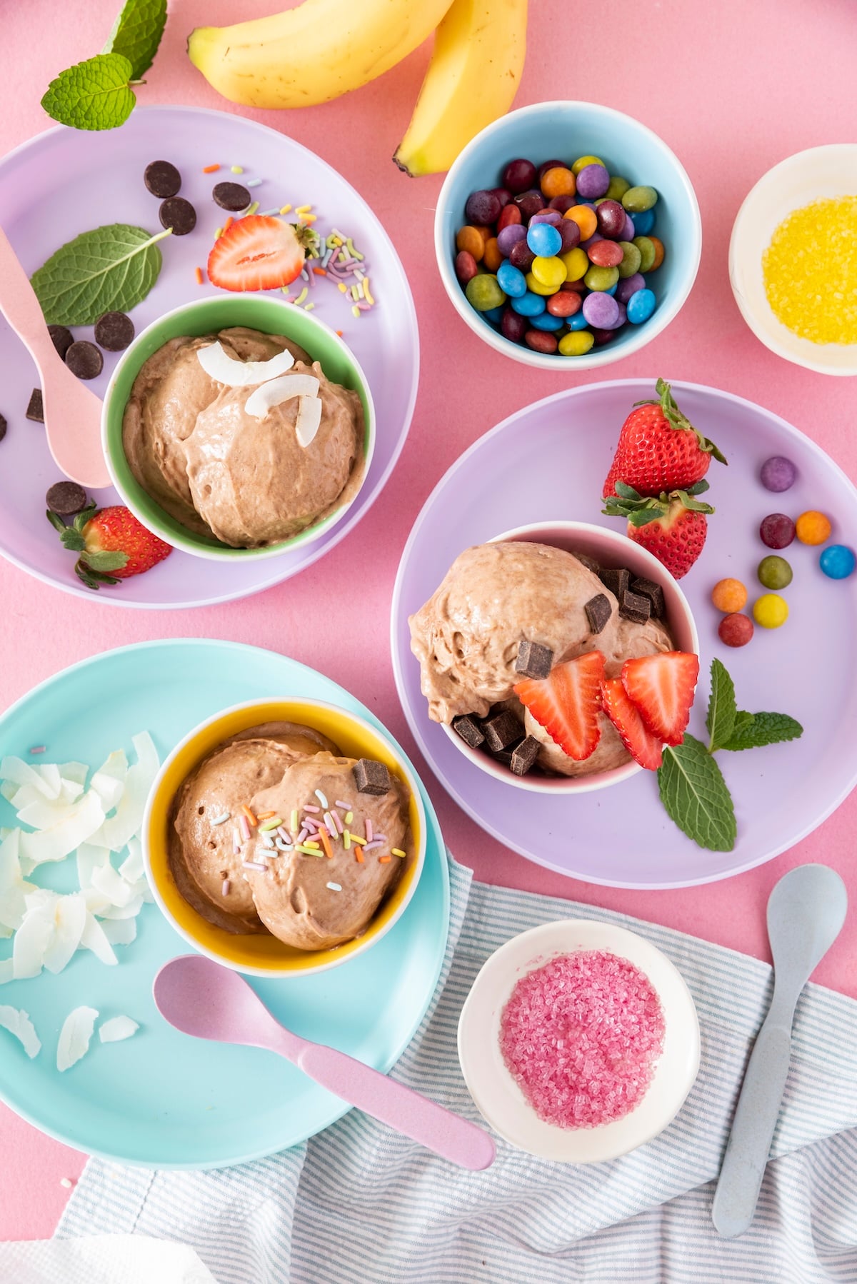Chocolate banana ice cream served in purple, blue and pink dishes.