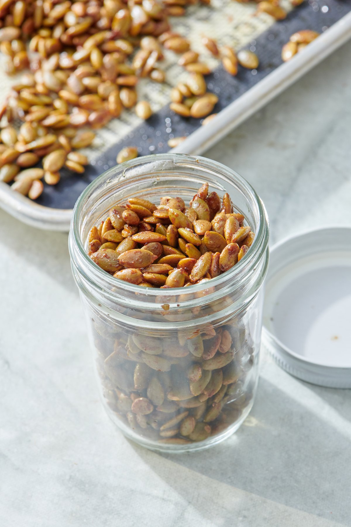 Glass jar filled with roasted pumpkin seeds.