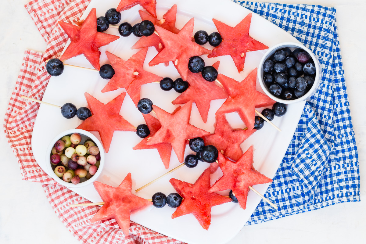platter with 4th of July fruit wands made up of star shaped watermelon chunks layered with blueberries