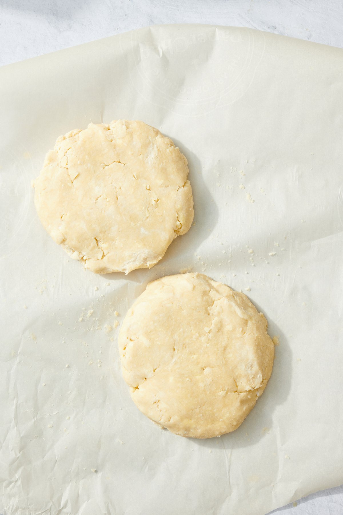 Pie dough separated into two disks.