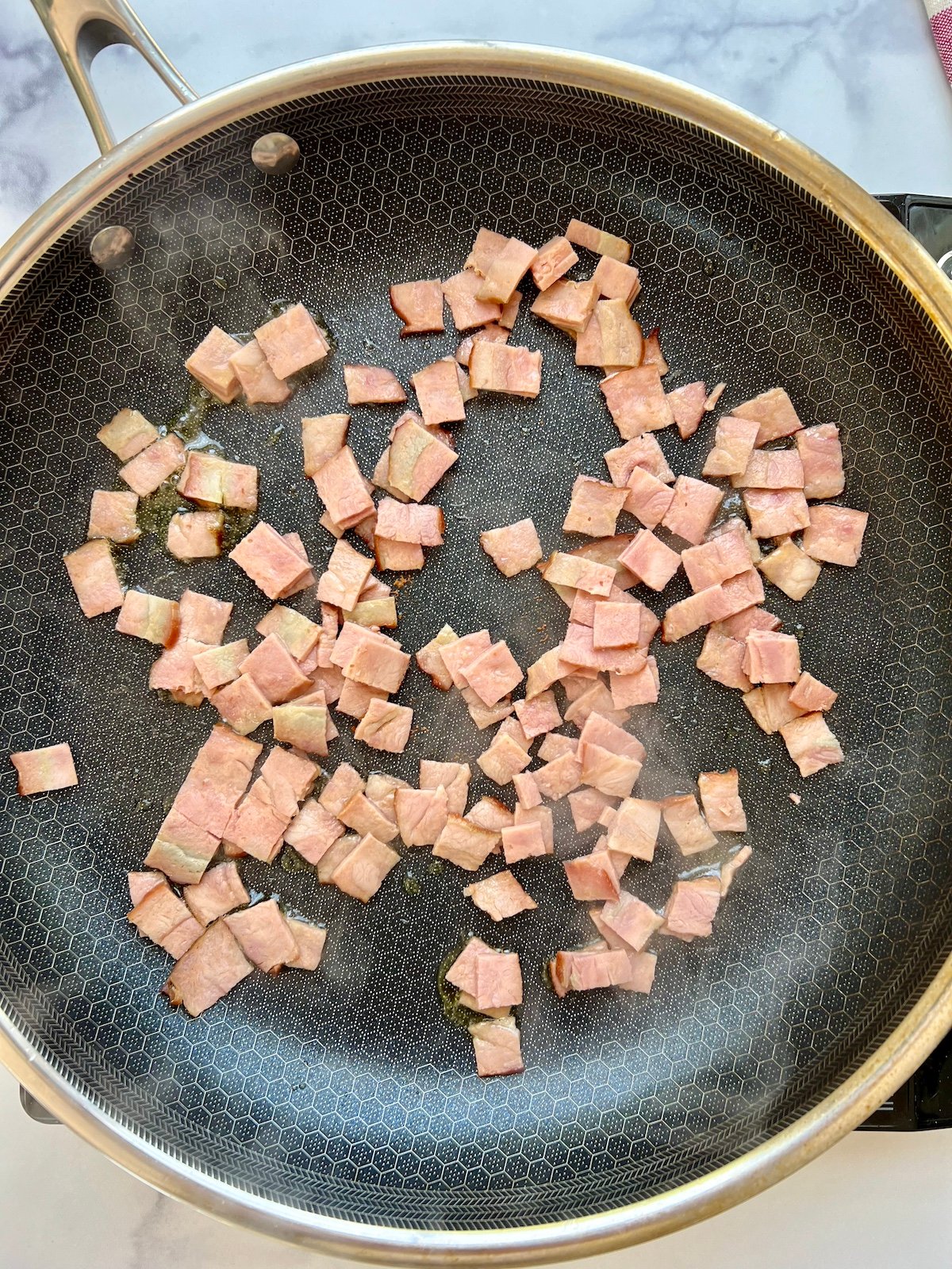 Chopped turkey bacon in sauté pan.
