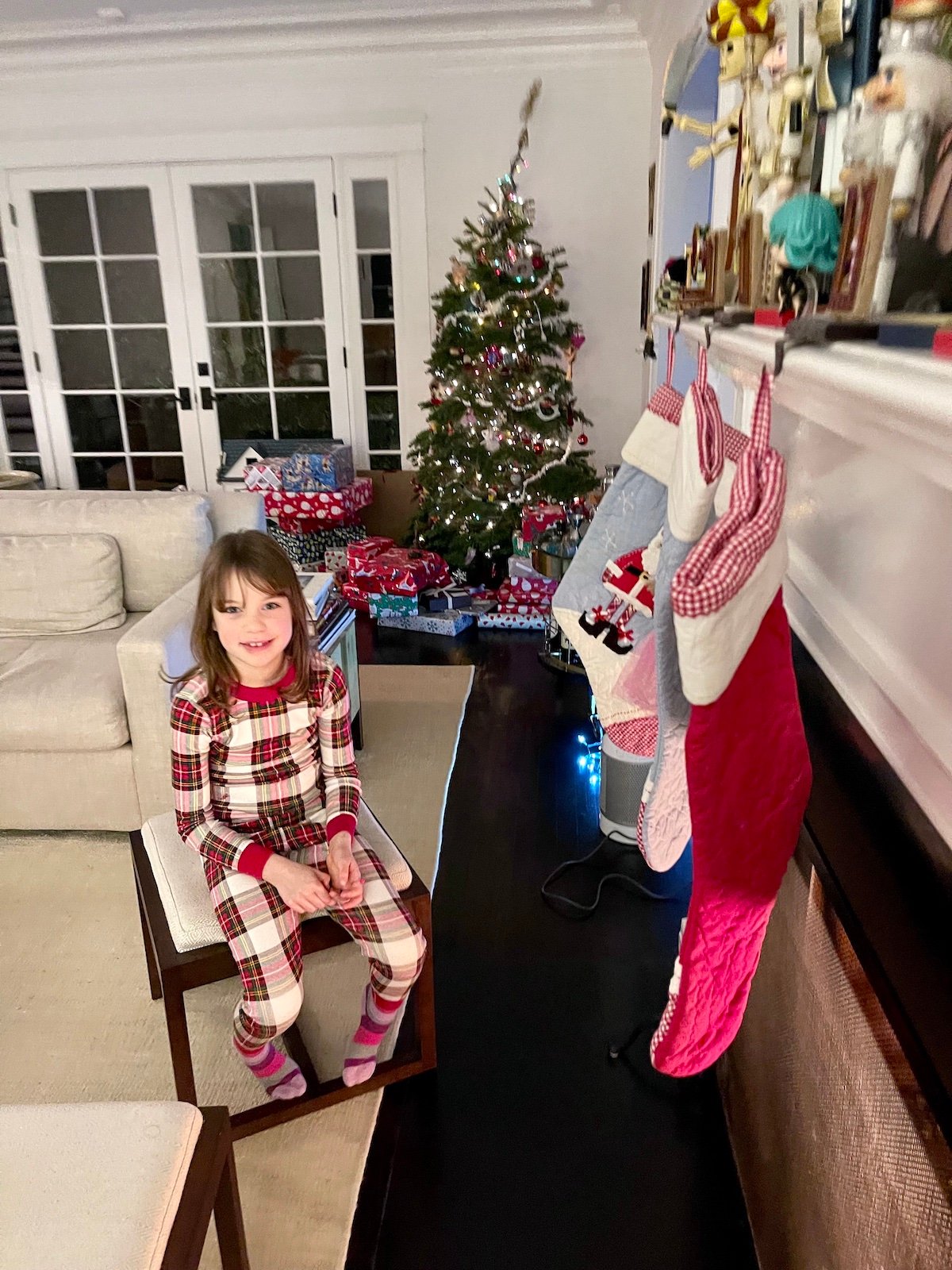 Young girl posed in living room decorated for the holidays.