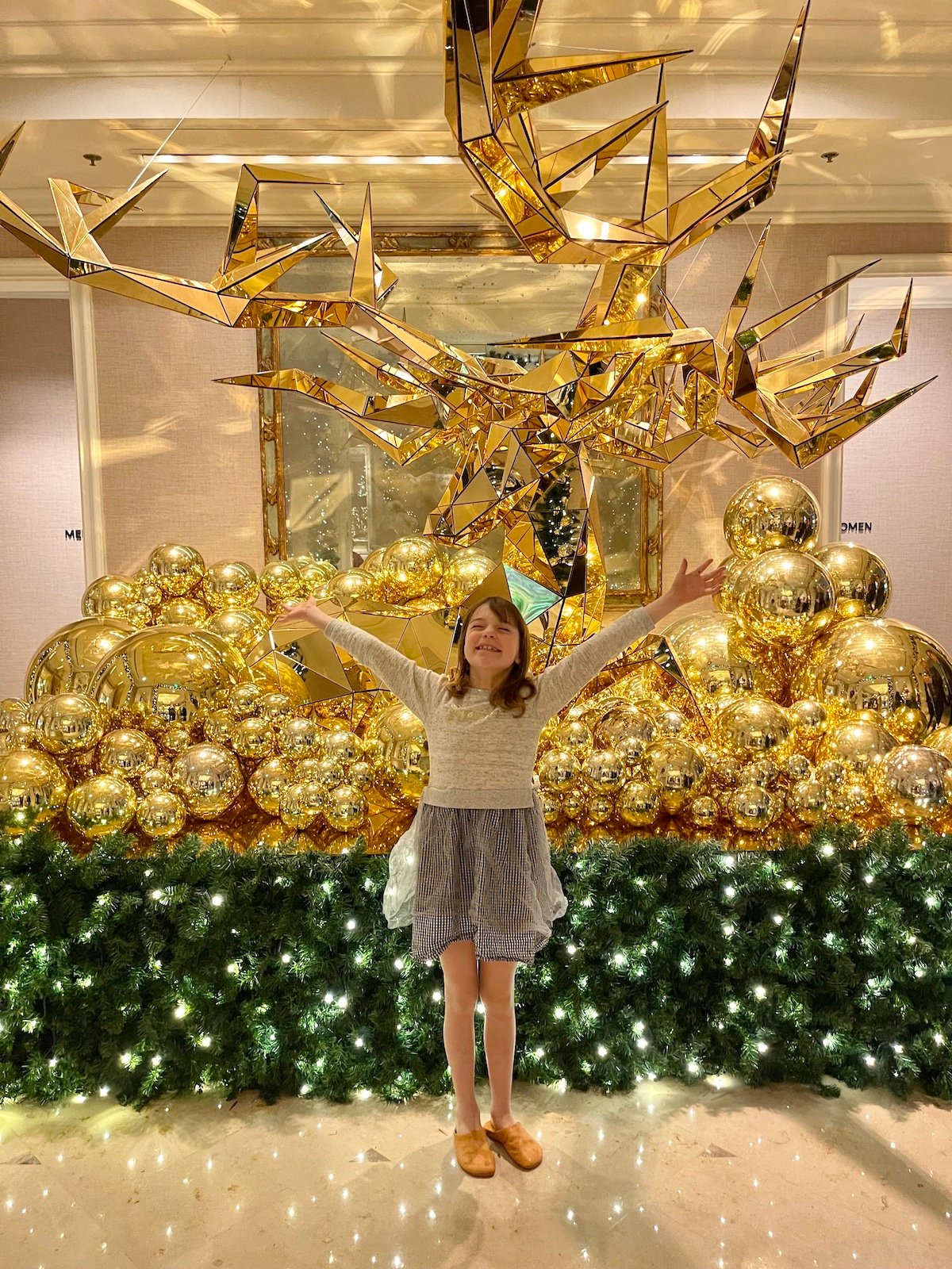 Young girl posing in front of holiday decorations. 