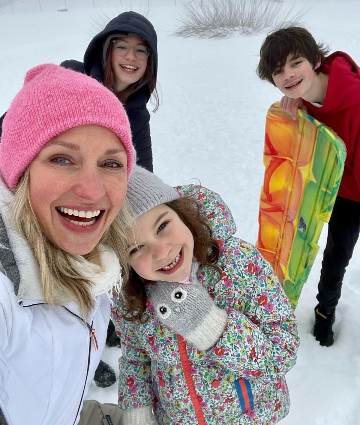 Family posing for the camera playing the in snow.