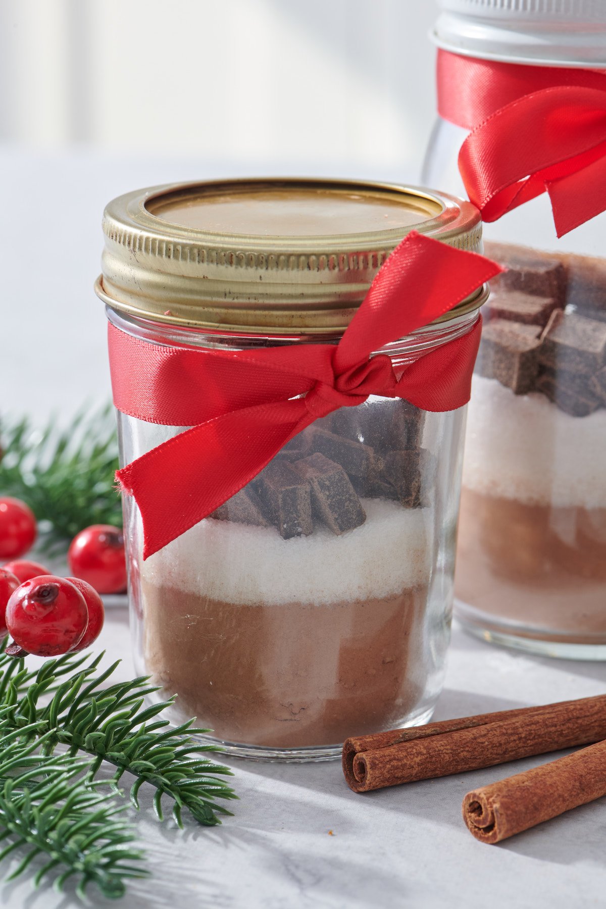 Mason Jar with red ribbon filled with hot cocoa mix.