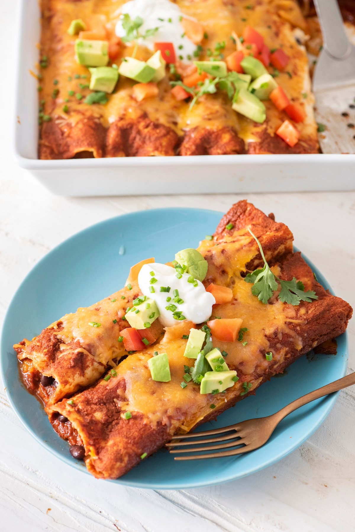 Two enchiladas on a plate.