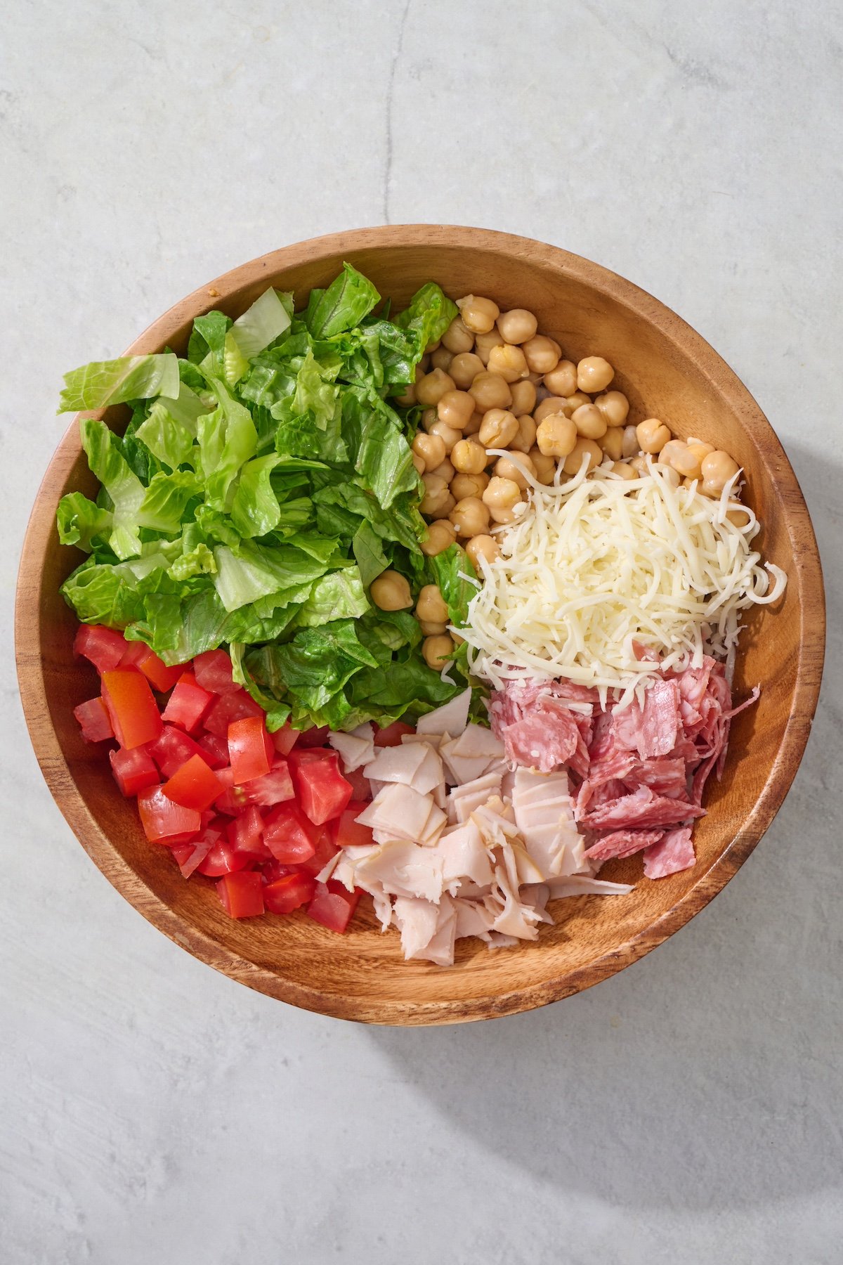 Italian chopped salad ingredients in a large salad bowl.