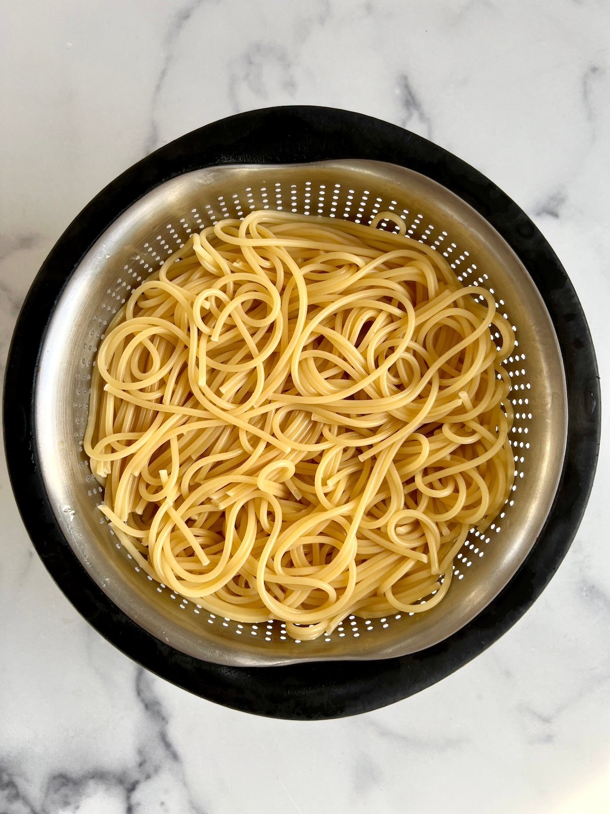 Cooked spaghetti in a colander.