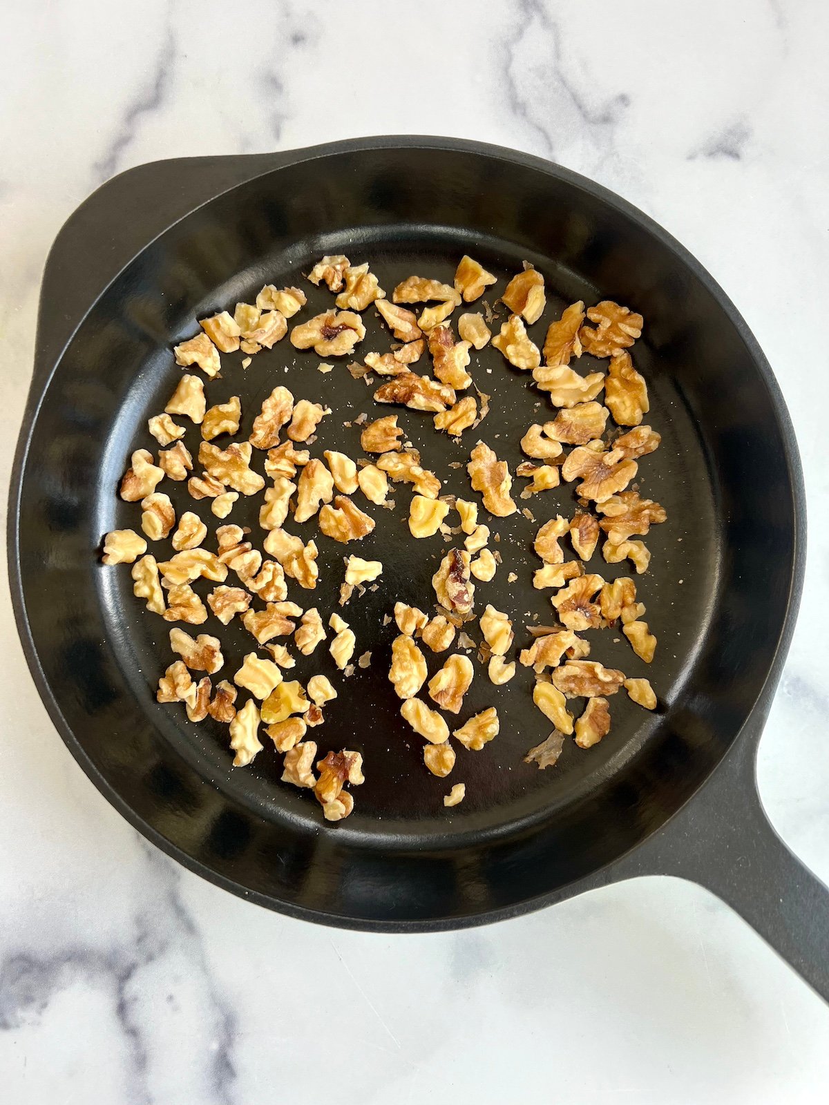 Toasted walnuts in sauté pan.