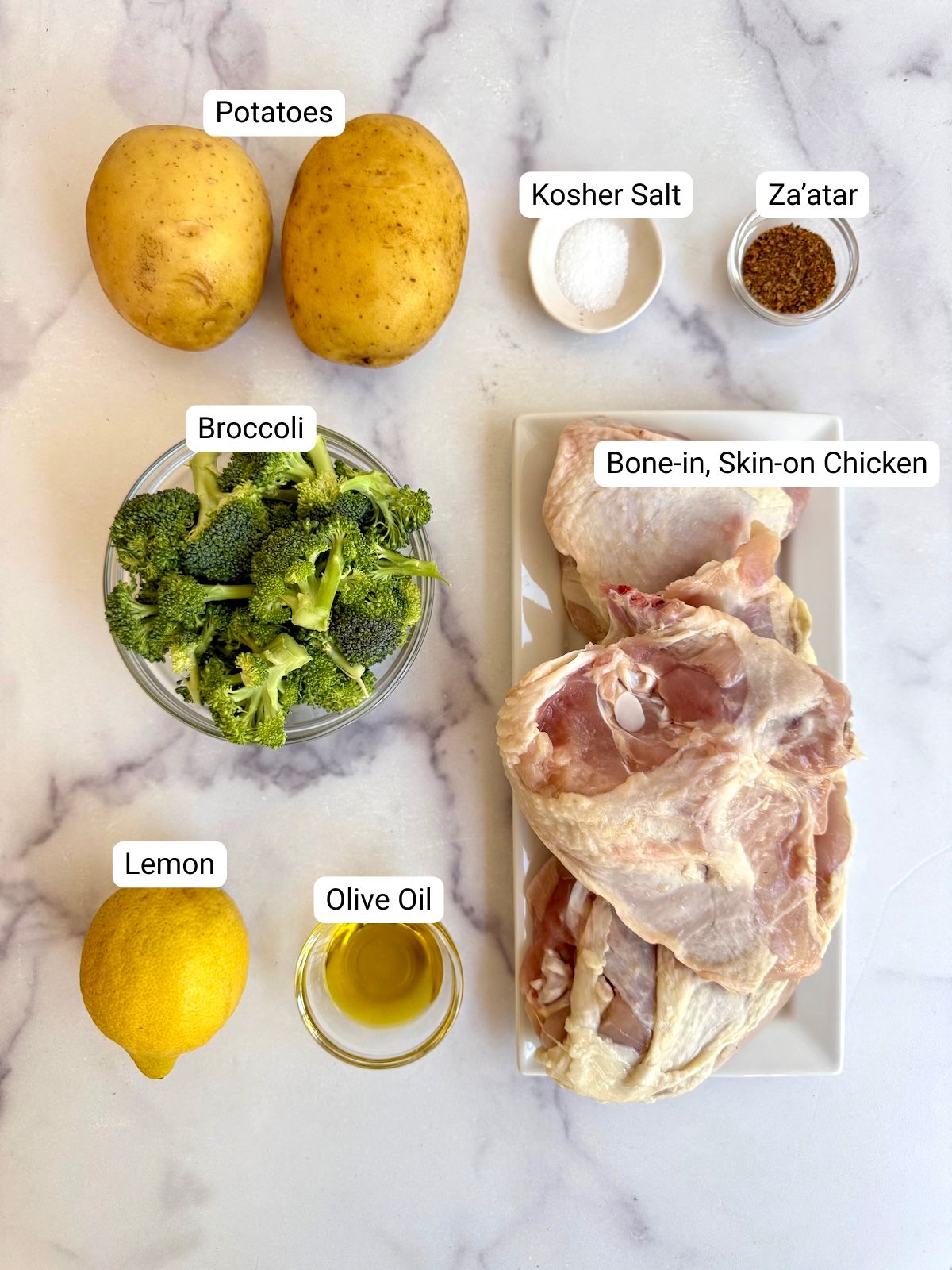 Ingredients for Middle Eastern sheet pan chicken: potatoes, kosher salt, za'atar, broccoli, lemon, olive oil, and bone-in skin-on chicken.