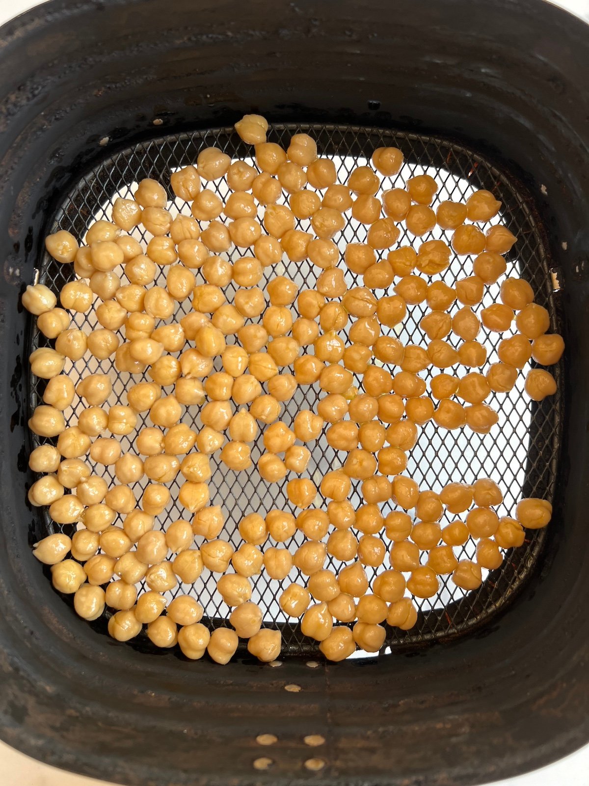 Chickpeas in air fryer basket.