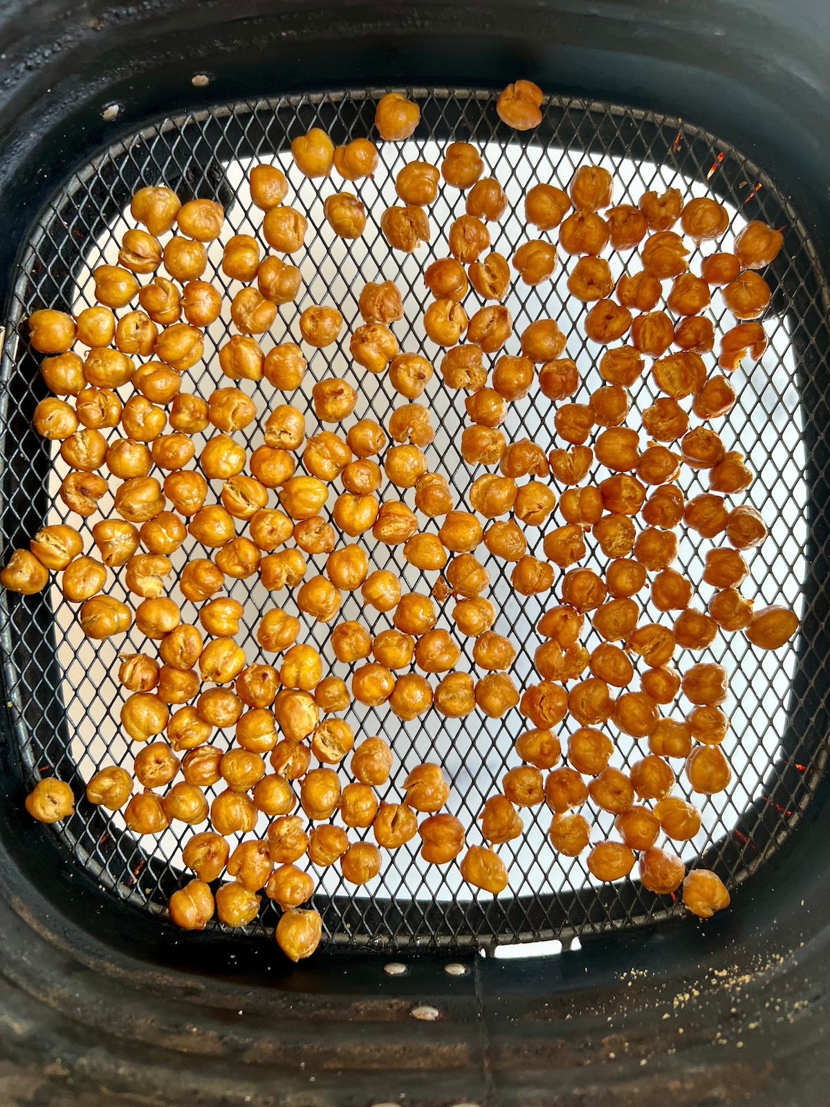 Roasted chickpeas in air fryer basket.