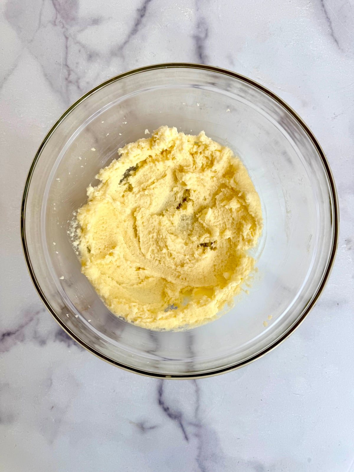 Creamed butter and sugar in a glass bowl for blackberry tea cake batter.