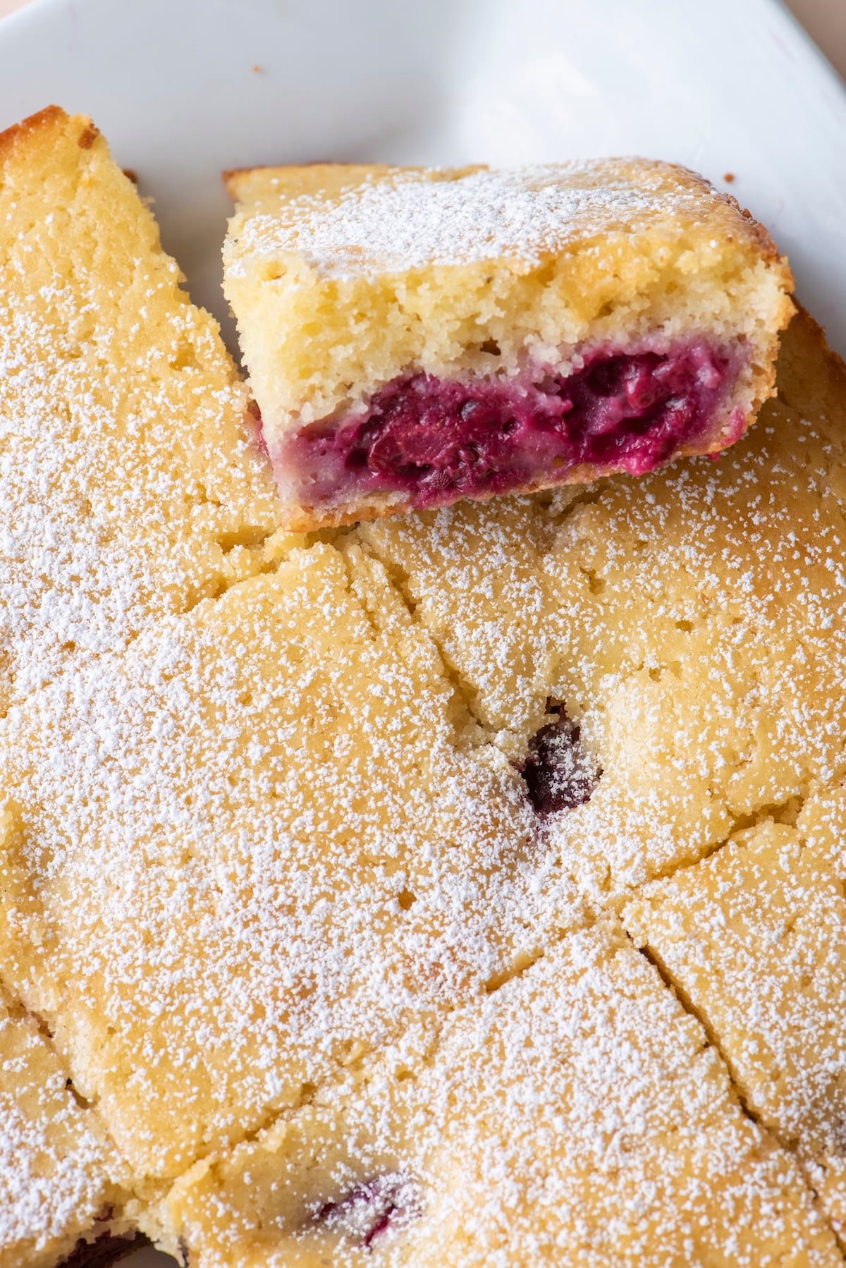 Close-up of a blackberry tea cake square showing the jammy blackberry layer inside the tender lemon cake.
