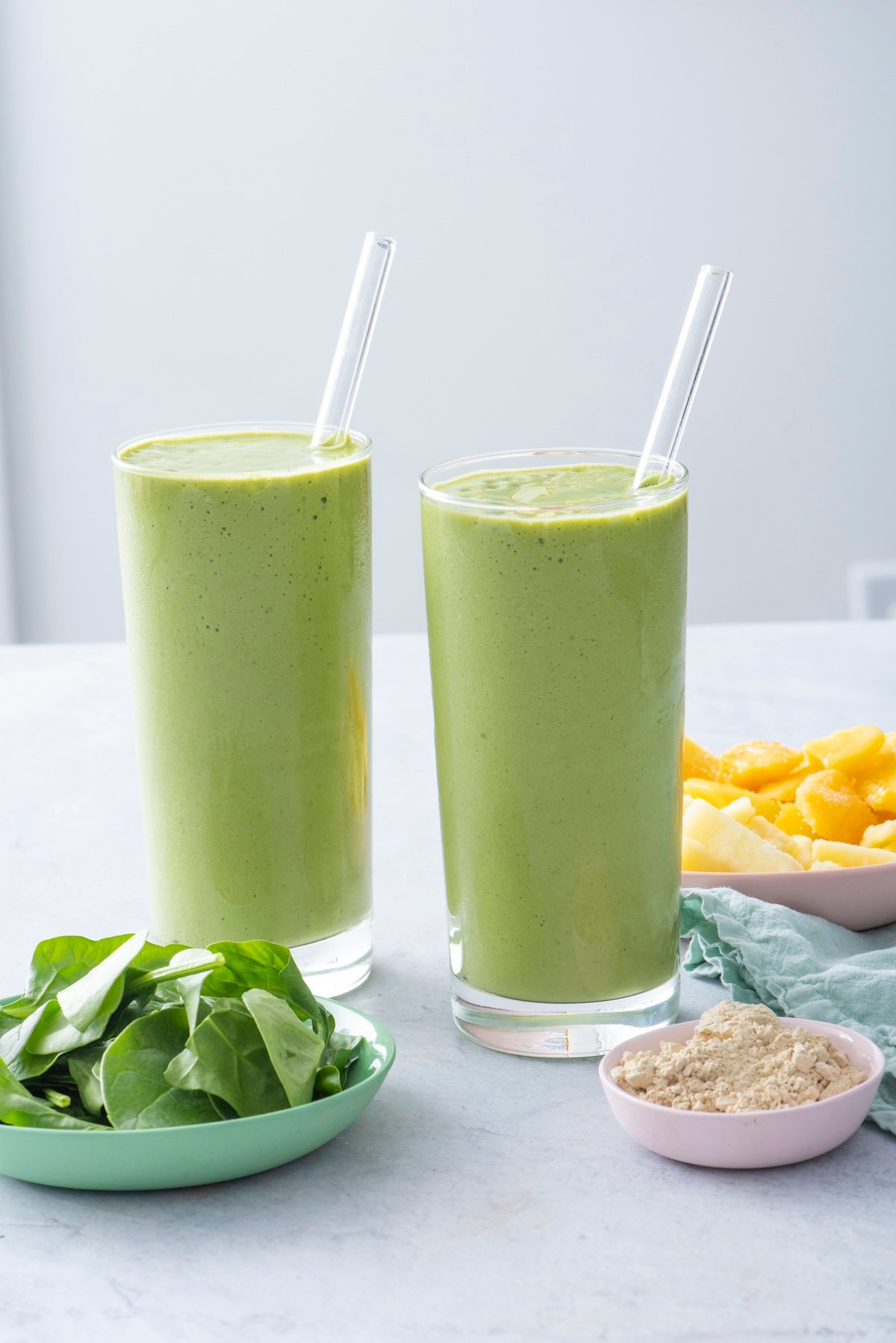 Two glasses with tropical protein greens smoothies.