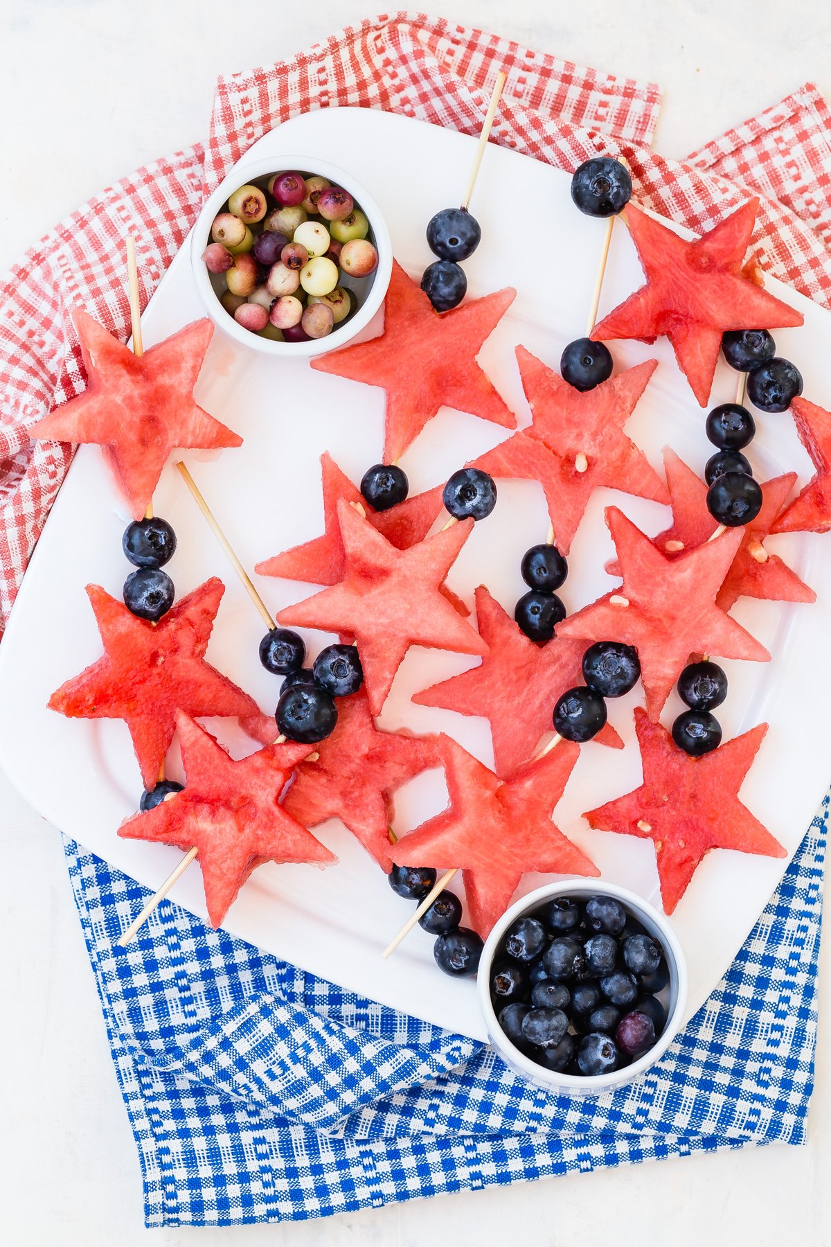 star shaped watermelon chunks and blueberries on a wooden skewer make these 4th of July fruit wands