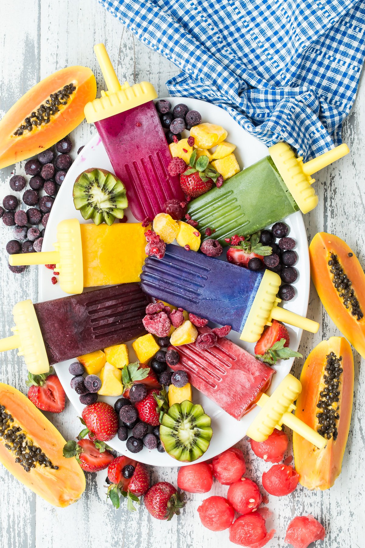 Rainbow Fruit Popsicles displayed on a plate. 