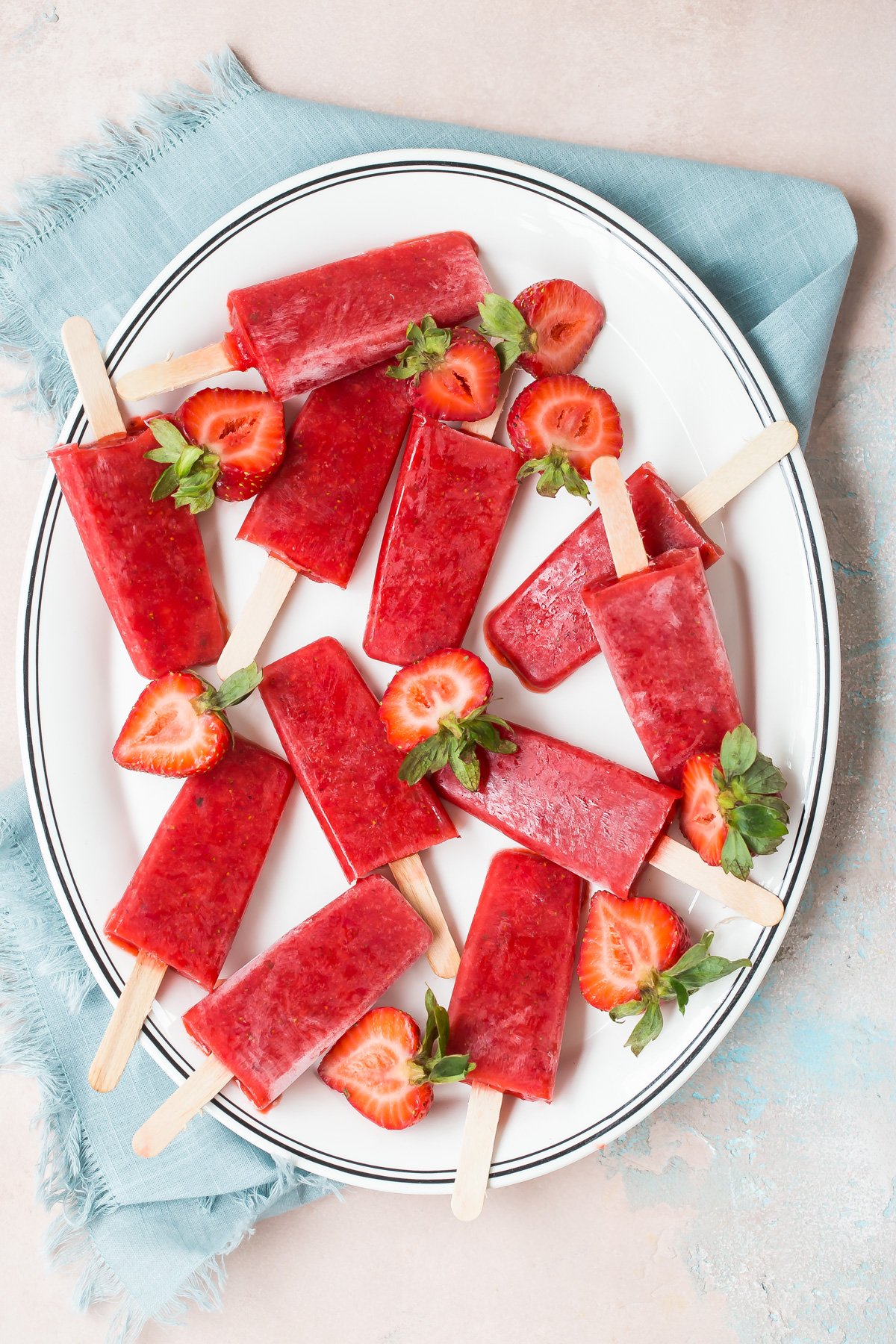 Strawberry popsicles on a plate.