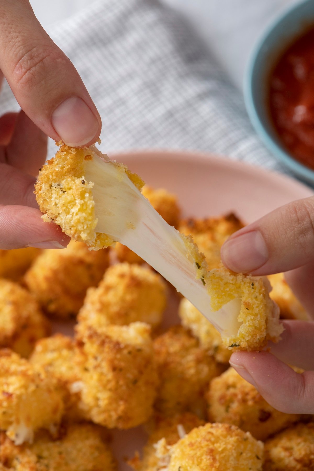Cheese bite being pulled apart.