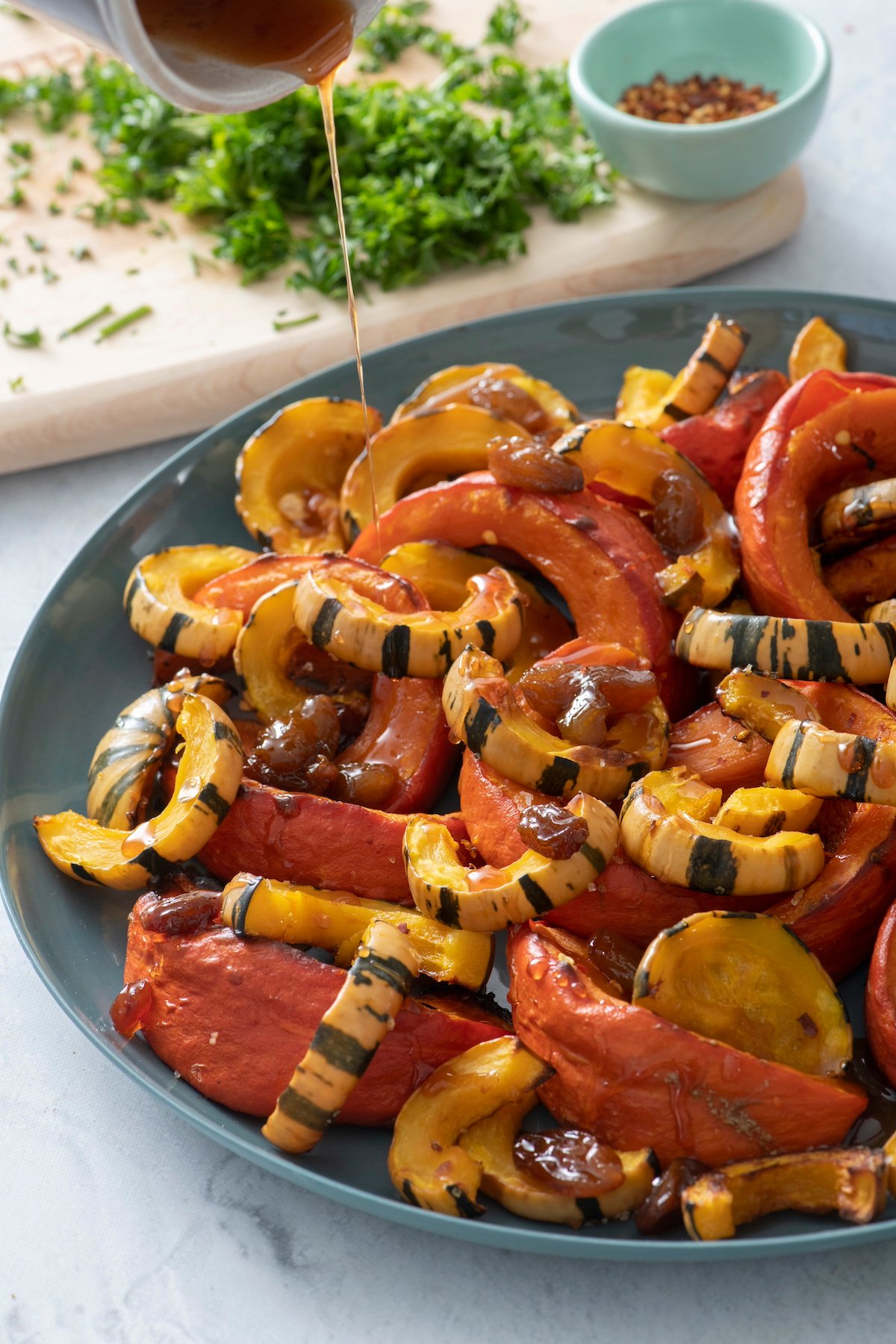 Pouring sweet and sour glaze over roasted squash.