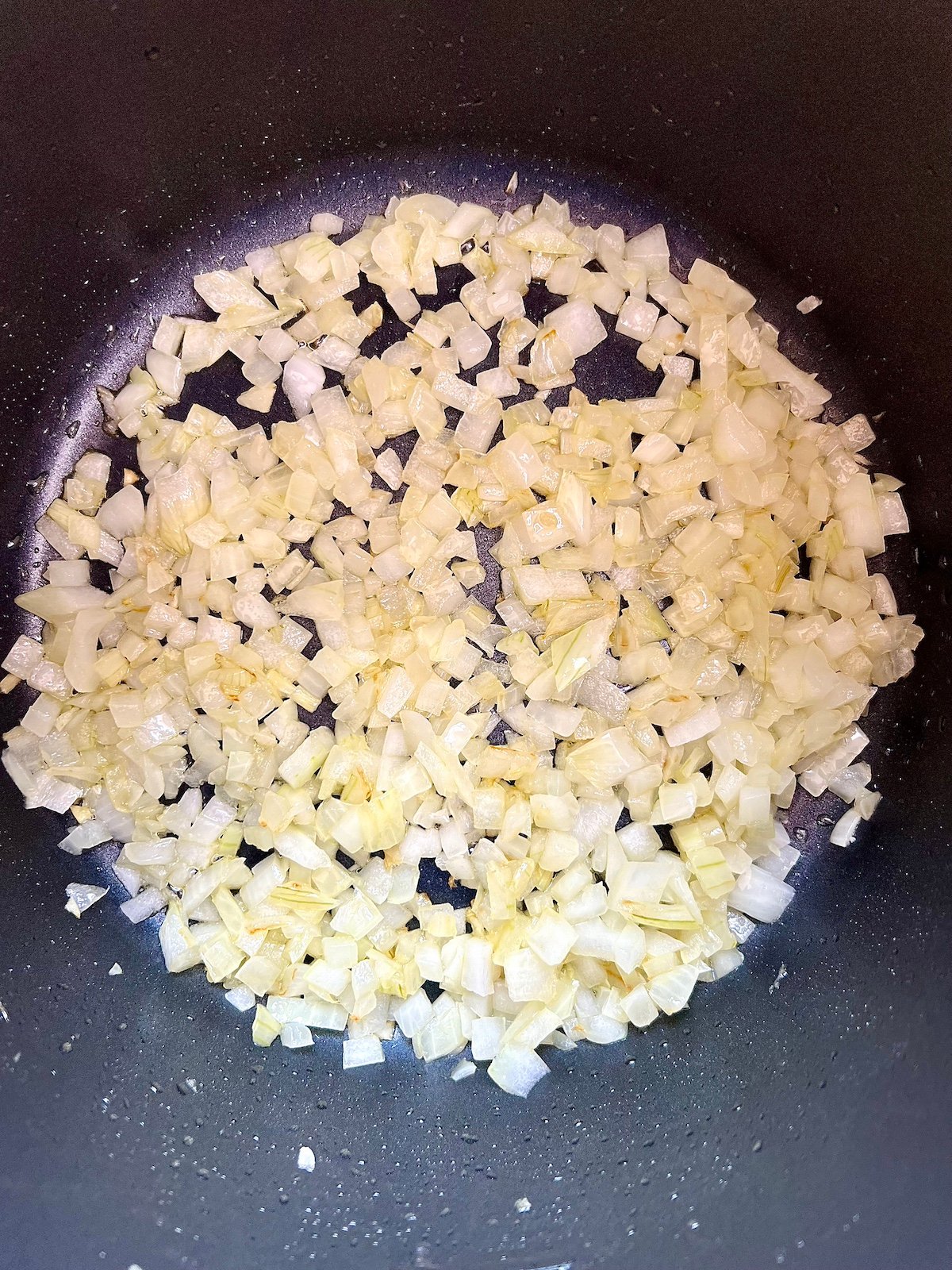 Chopped onions sautéing  in pan.
