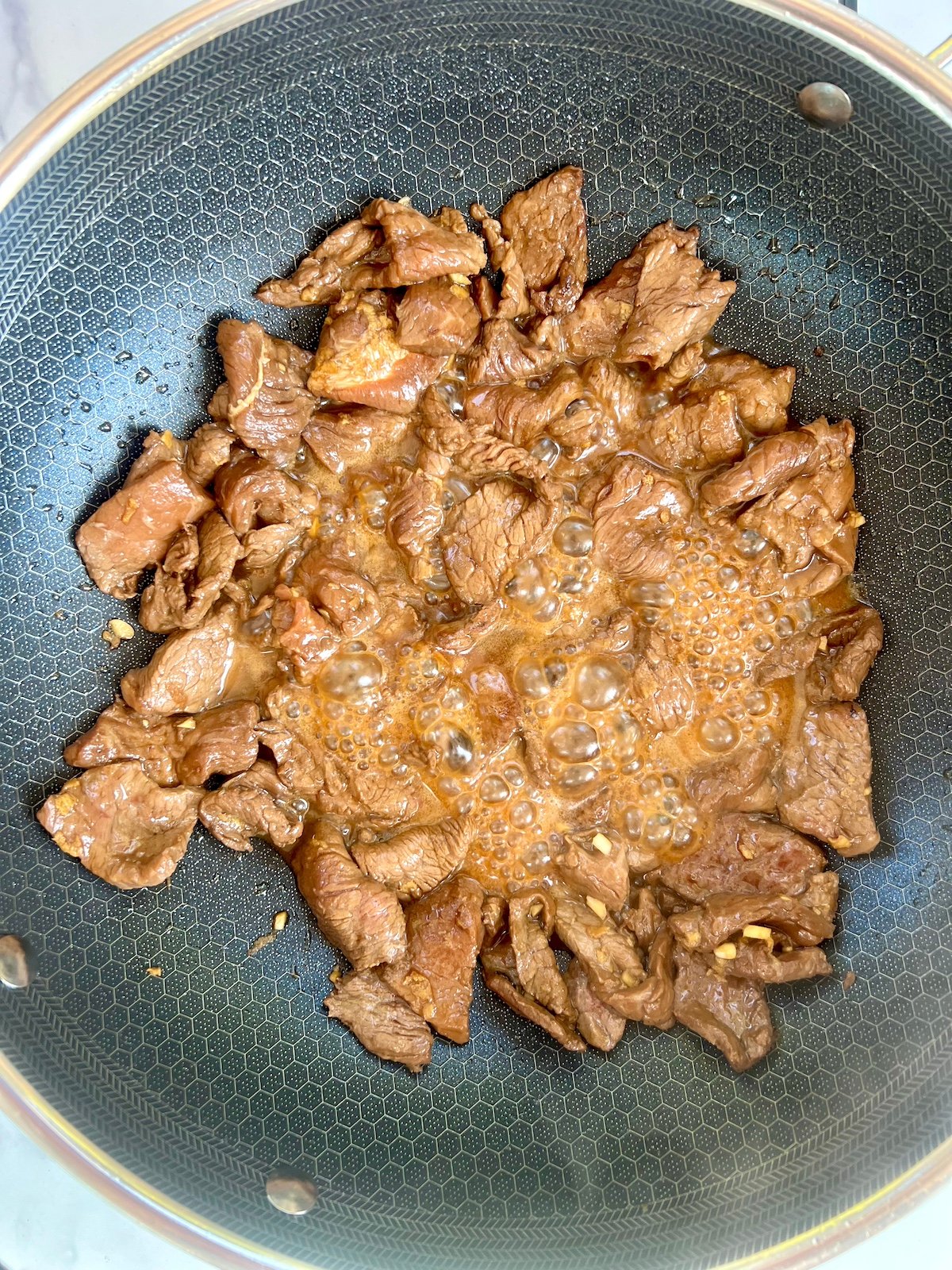 Steak cooking in sauté pan.