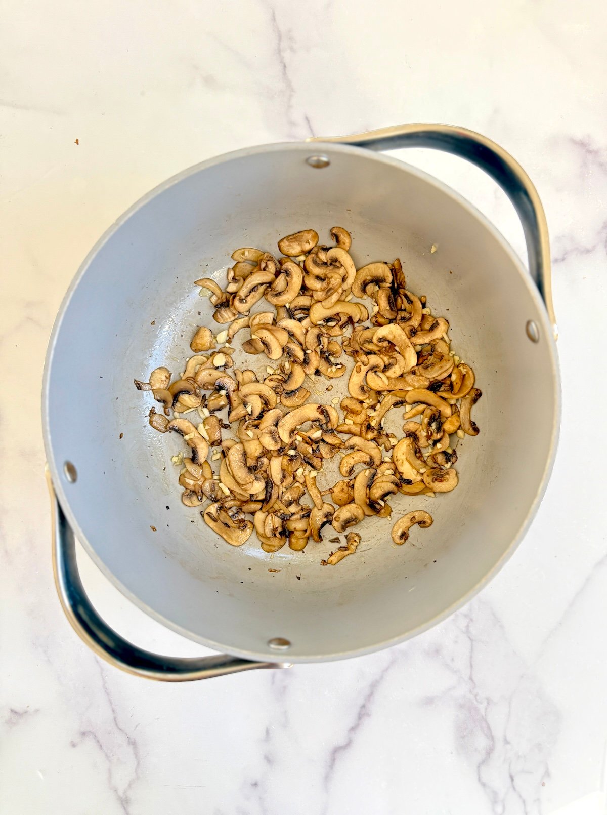 Sauteed mushrooms in a large pot.
