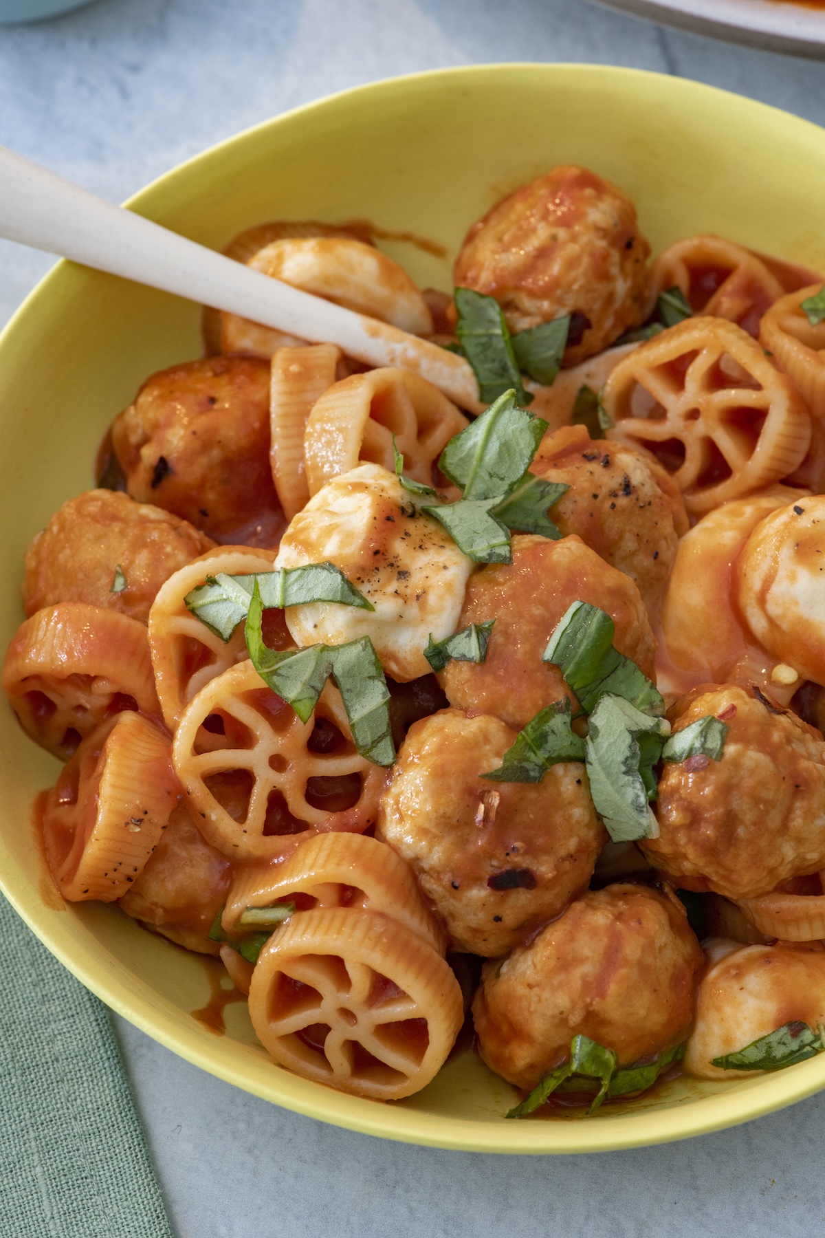 Serving of chicken meatballs with mini wheel pasta in a bowl.