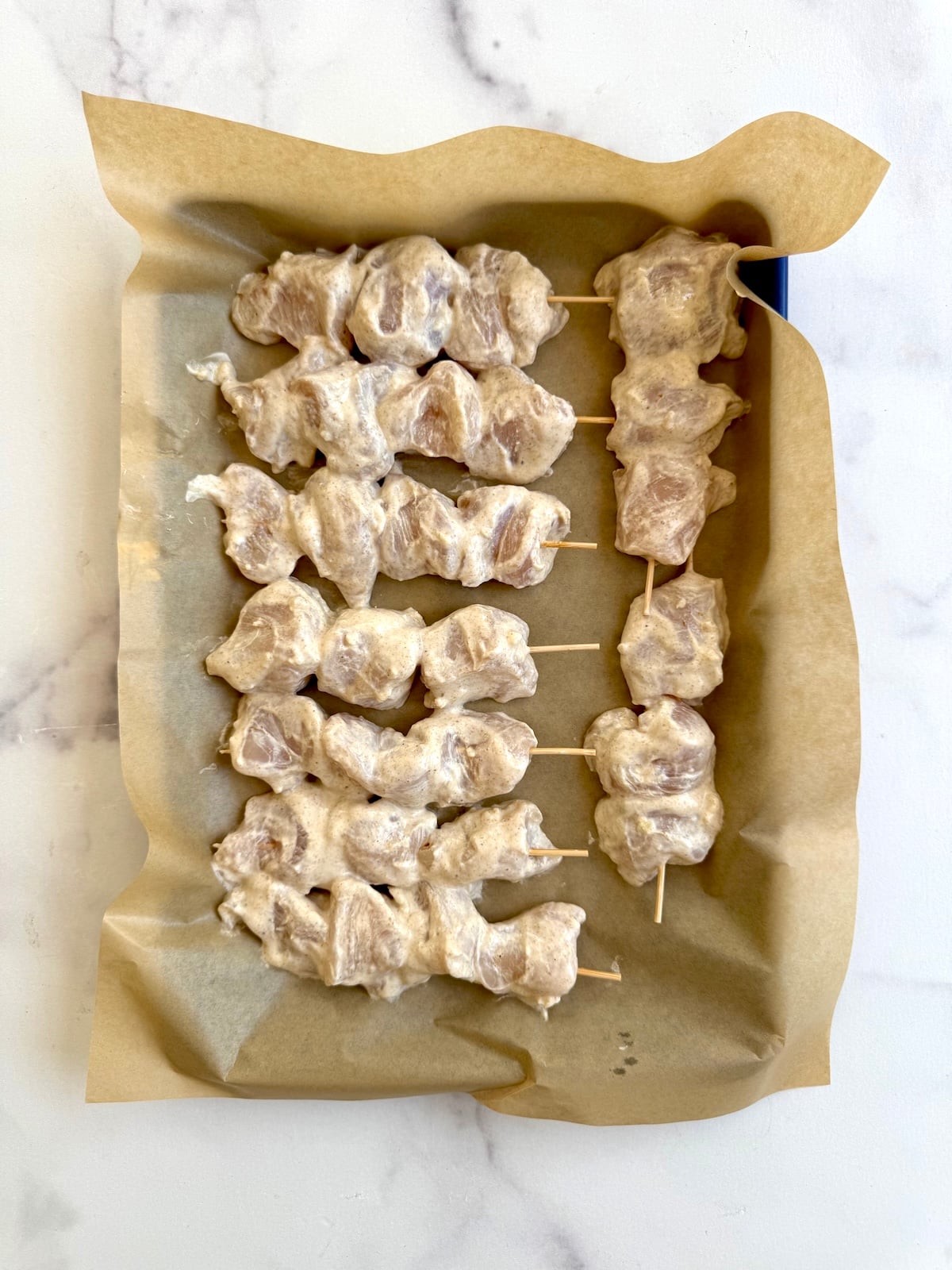 Chicken tikka skewers on a baking sheet.