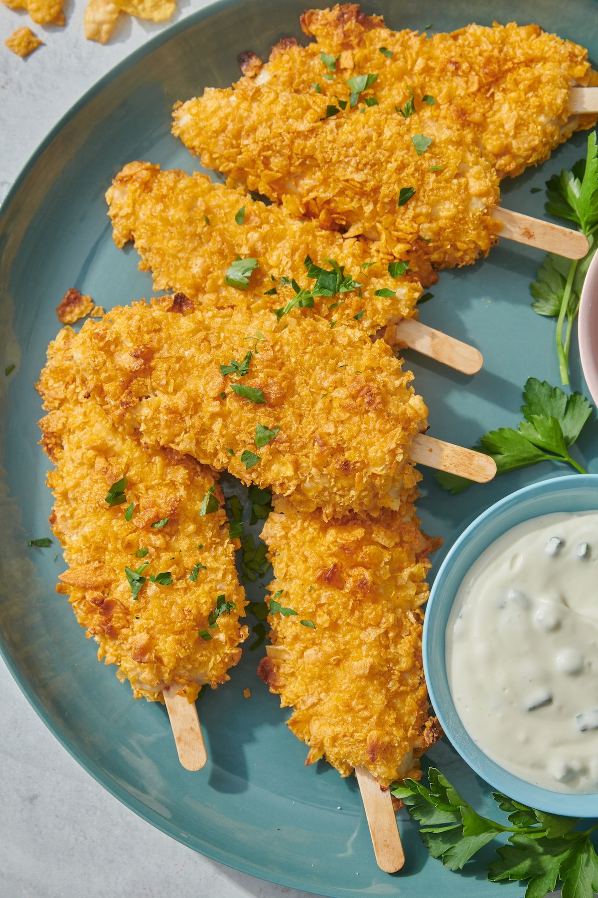 Chicken on a stick served on a platter with ranch dressing.