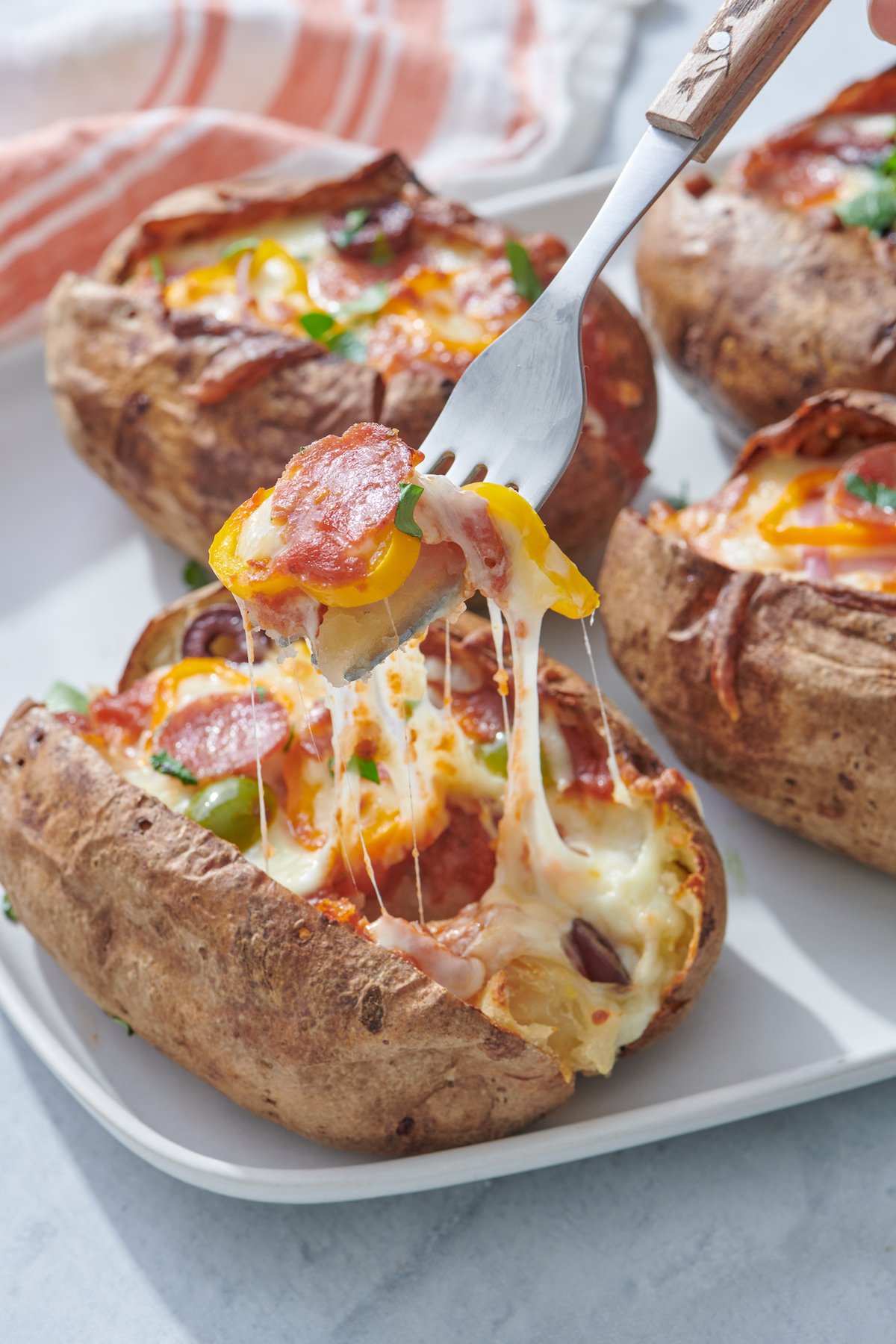 fork with baked potato, cheese, pepperoni and yellow pepper