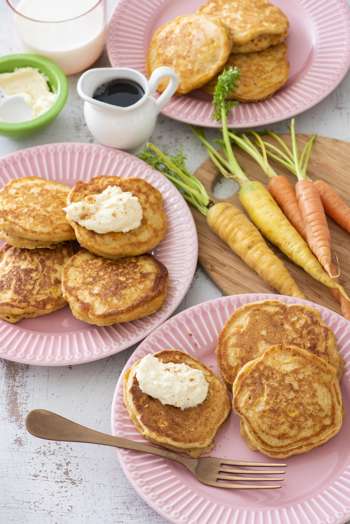 carrot cake pancakes on a plate next to raw carrots