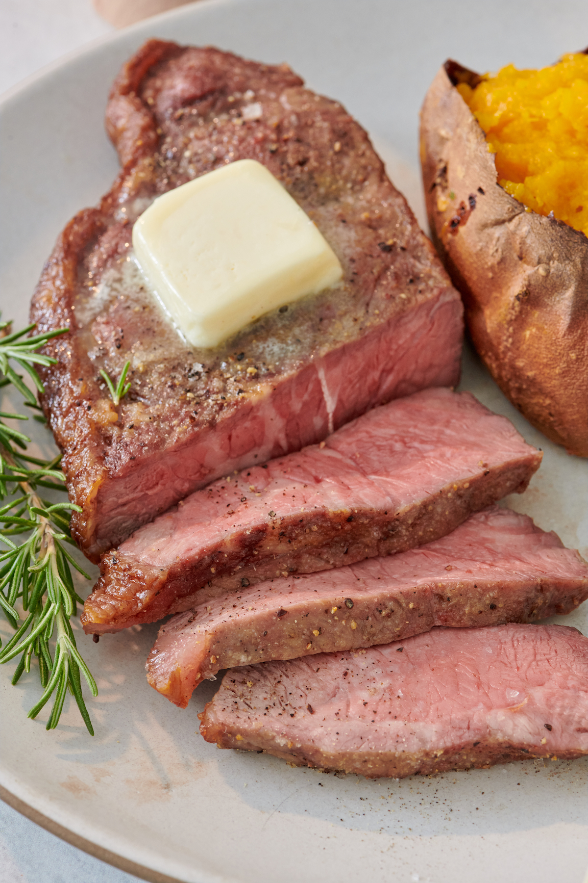 Air Fryer Steak sliced and topped with butter.