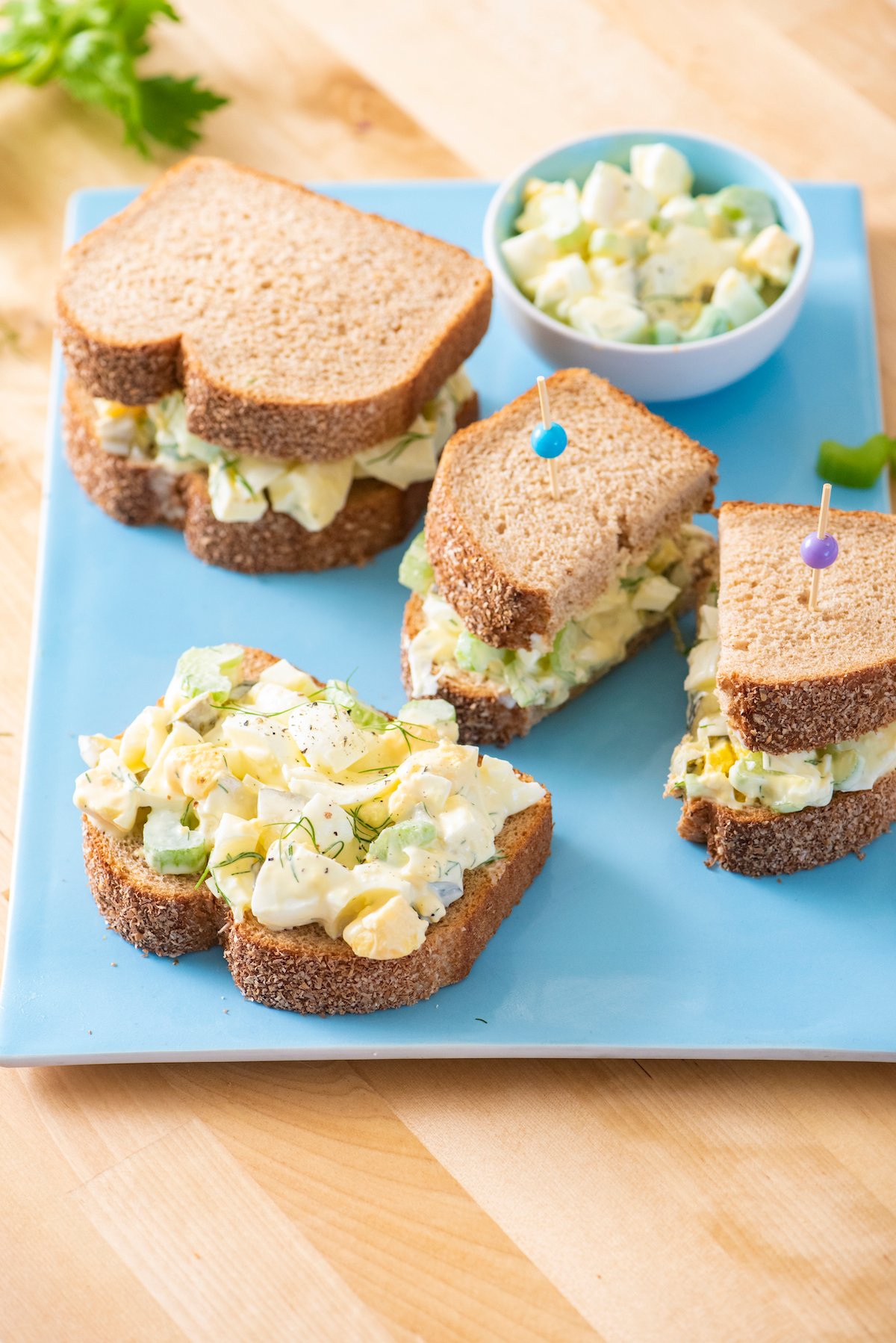 Three egg salad sandwiches on a serving platter.