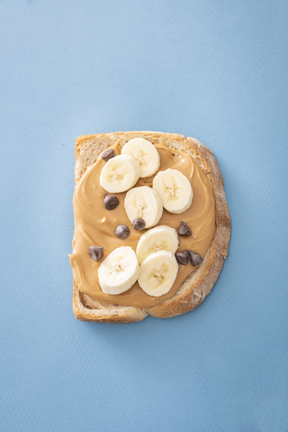 open face sandwich with peanut butter, bananas and chocolate chips