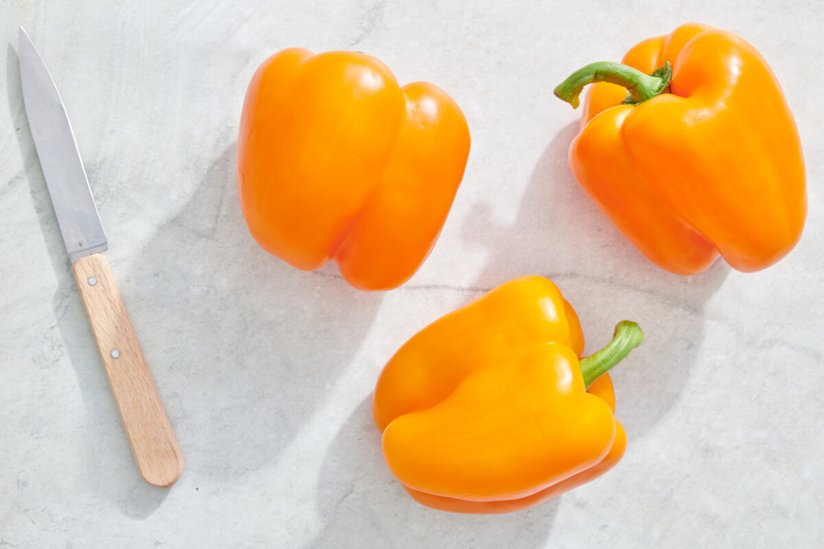 Orange bell peppers and parring knife.