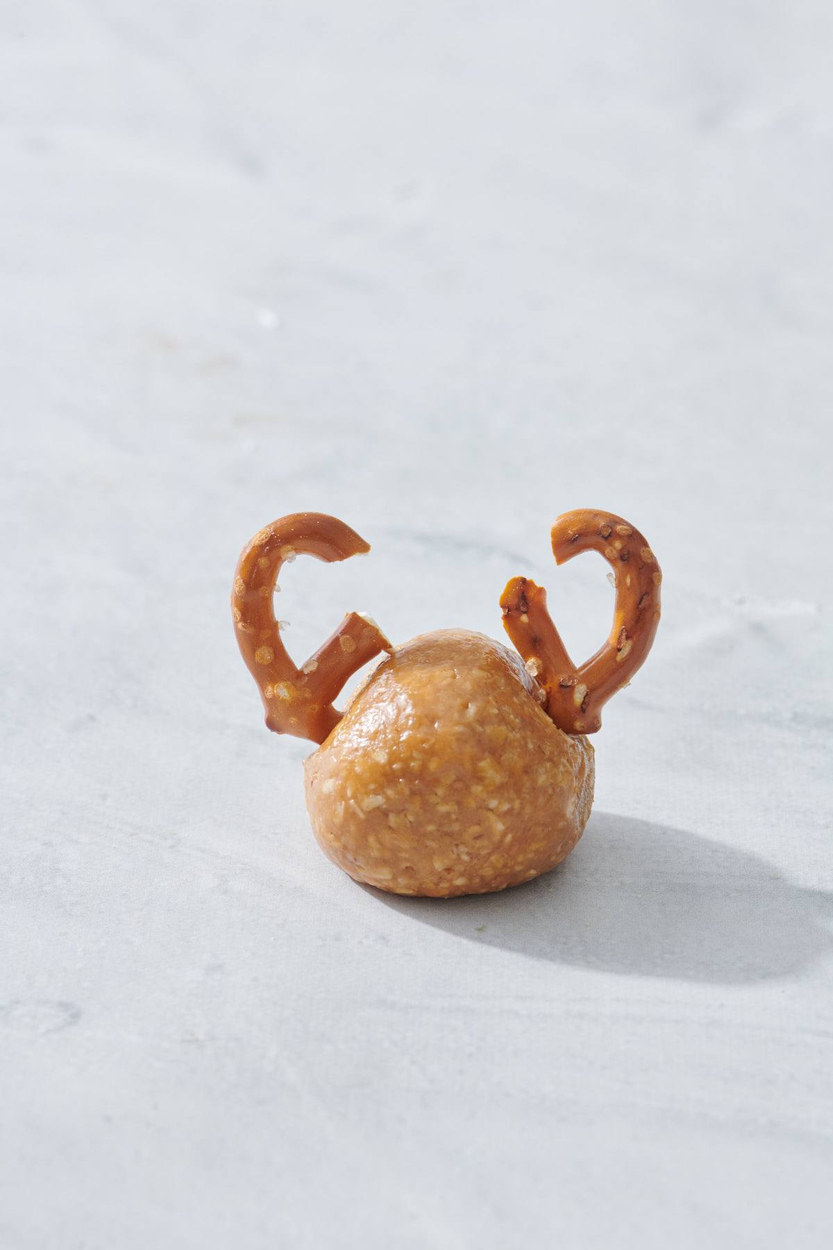 peanut butter oatmeal ball with pretzels that resemble antlers